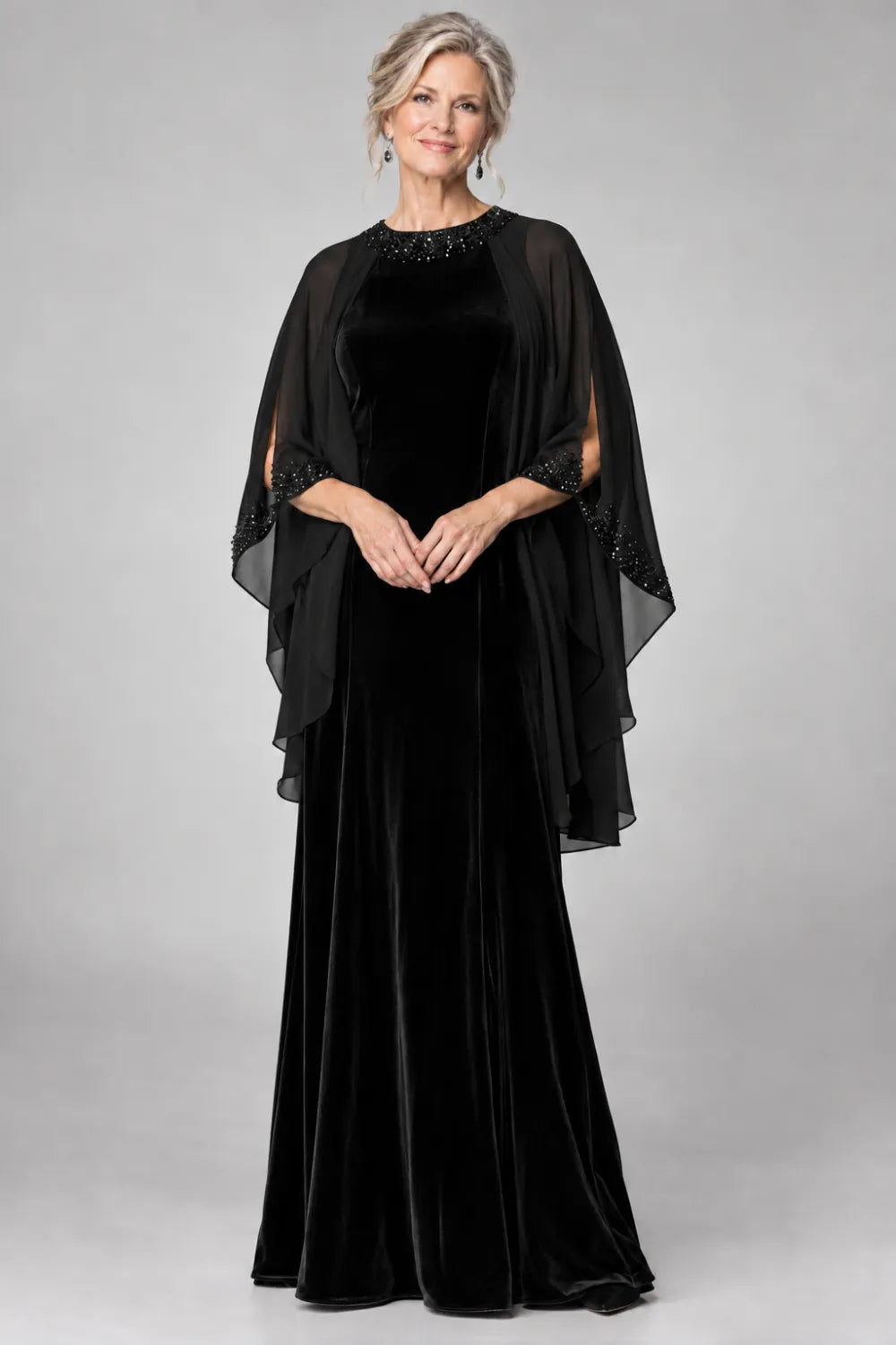 Black dress with beaded round neckline and cascading sheer cape, front view.