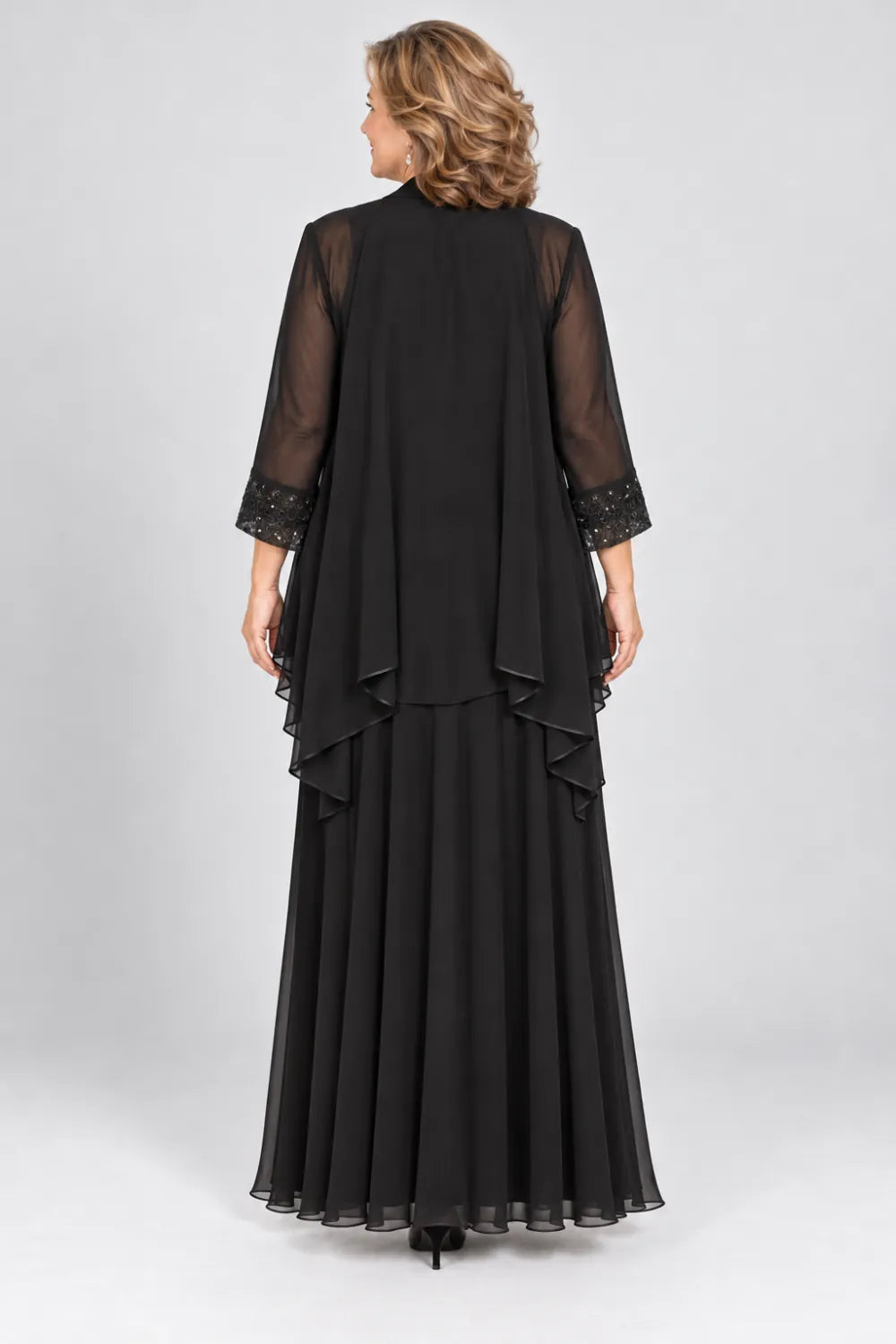 Back view of a black ankle-length dress with a sheer waterfall jacket and three-quarter sleeves.