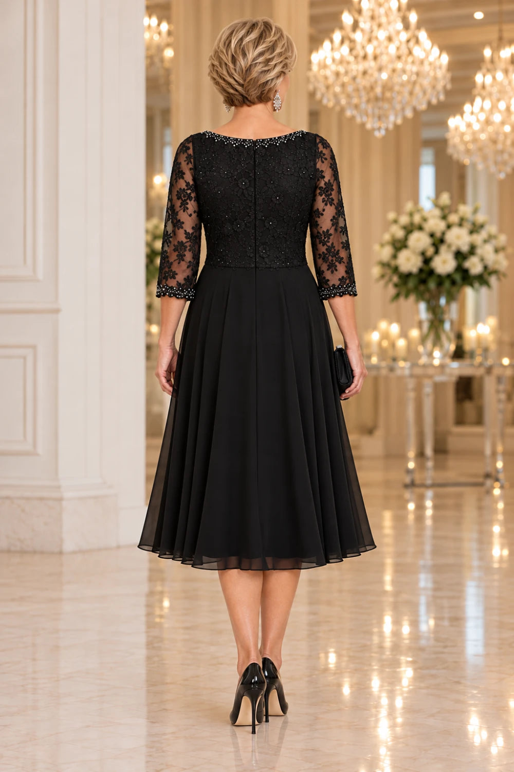 Direct back view of the black dress showing the lace-covered rear bodice, horizontal waist seam and plain midi skirt.