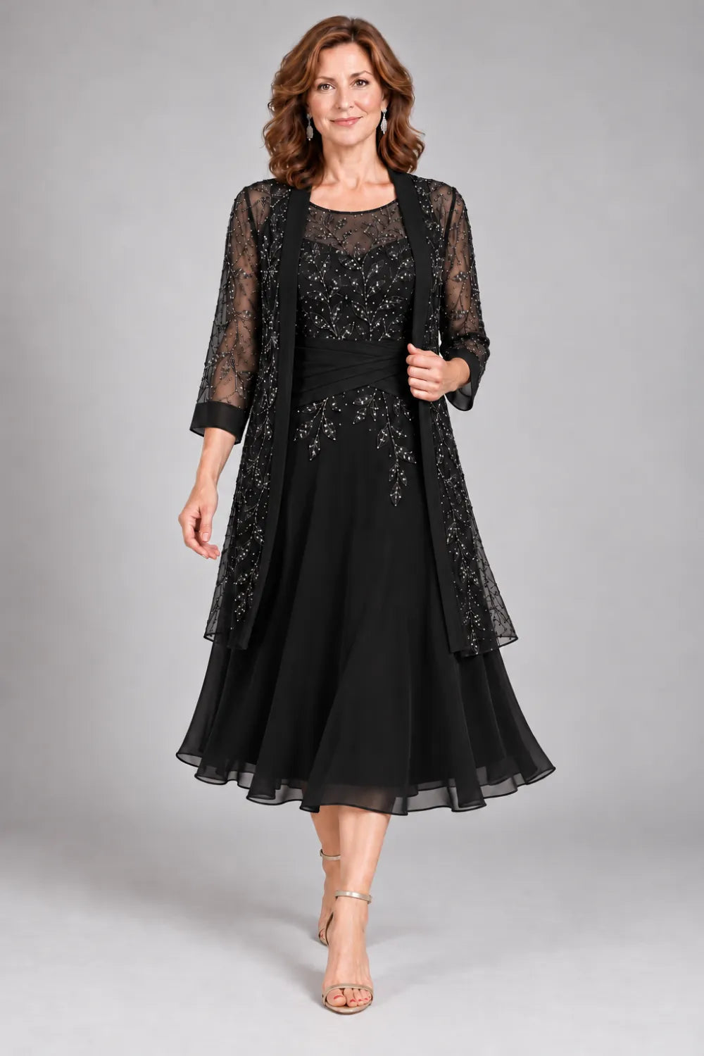 Black dress with floral lace extending below the waist, front view.