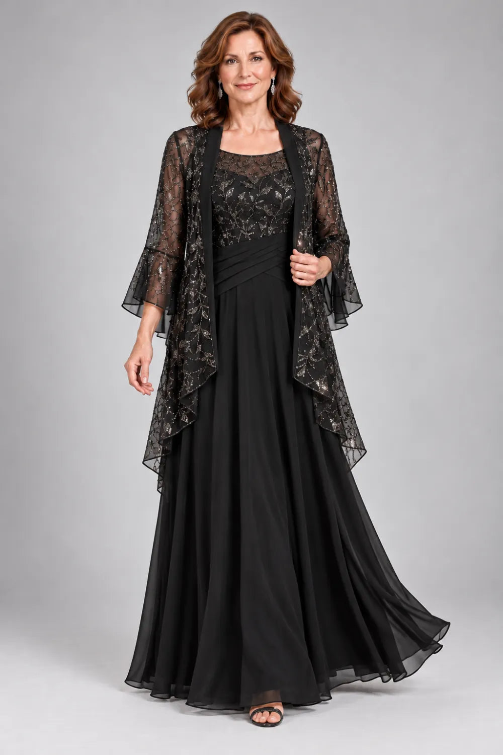 Black dress with floral decorated bodice and diagonal gathered waist, posed front view.