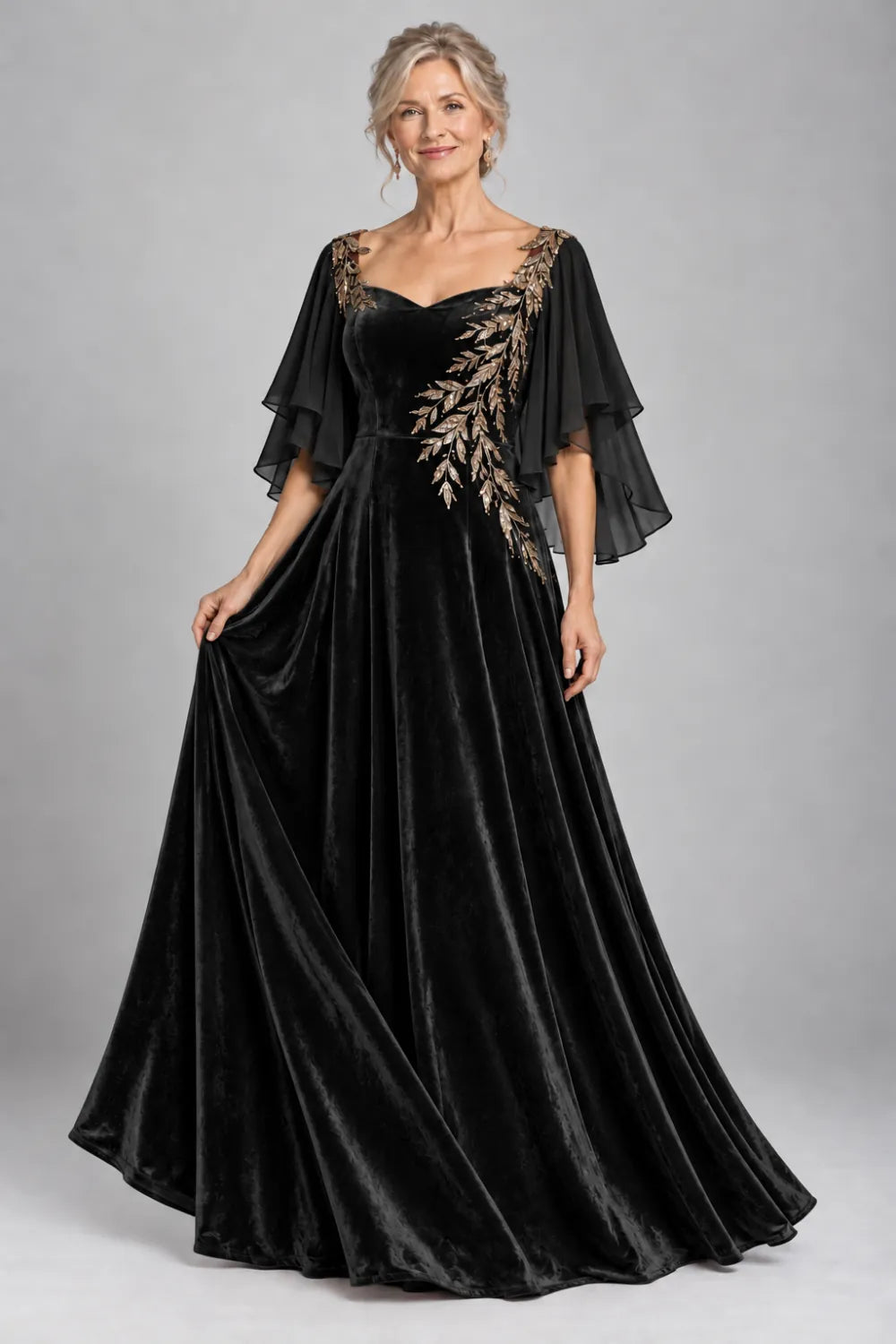 Black dress with diagonal gold-tone leaf embroidery, front view.