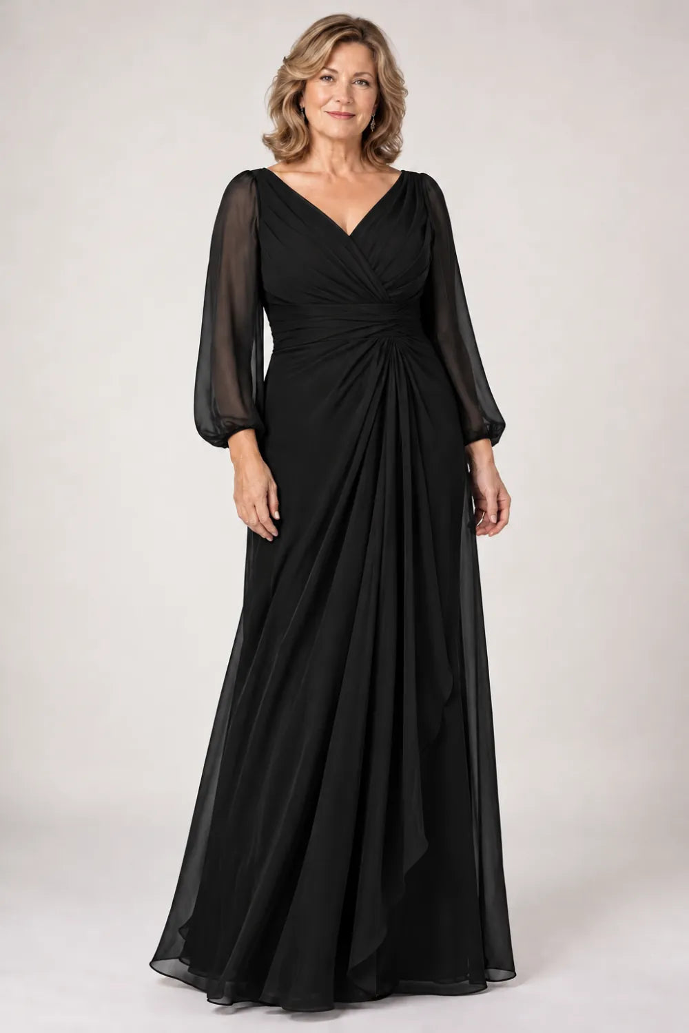 Black dress with crossover bodice, gathered waist and cascading side panel, front view.