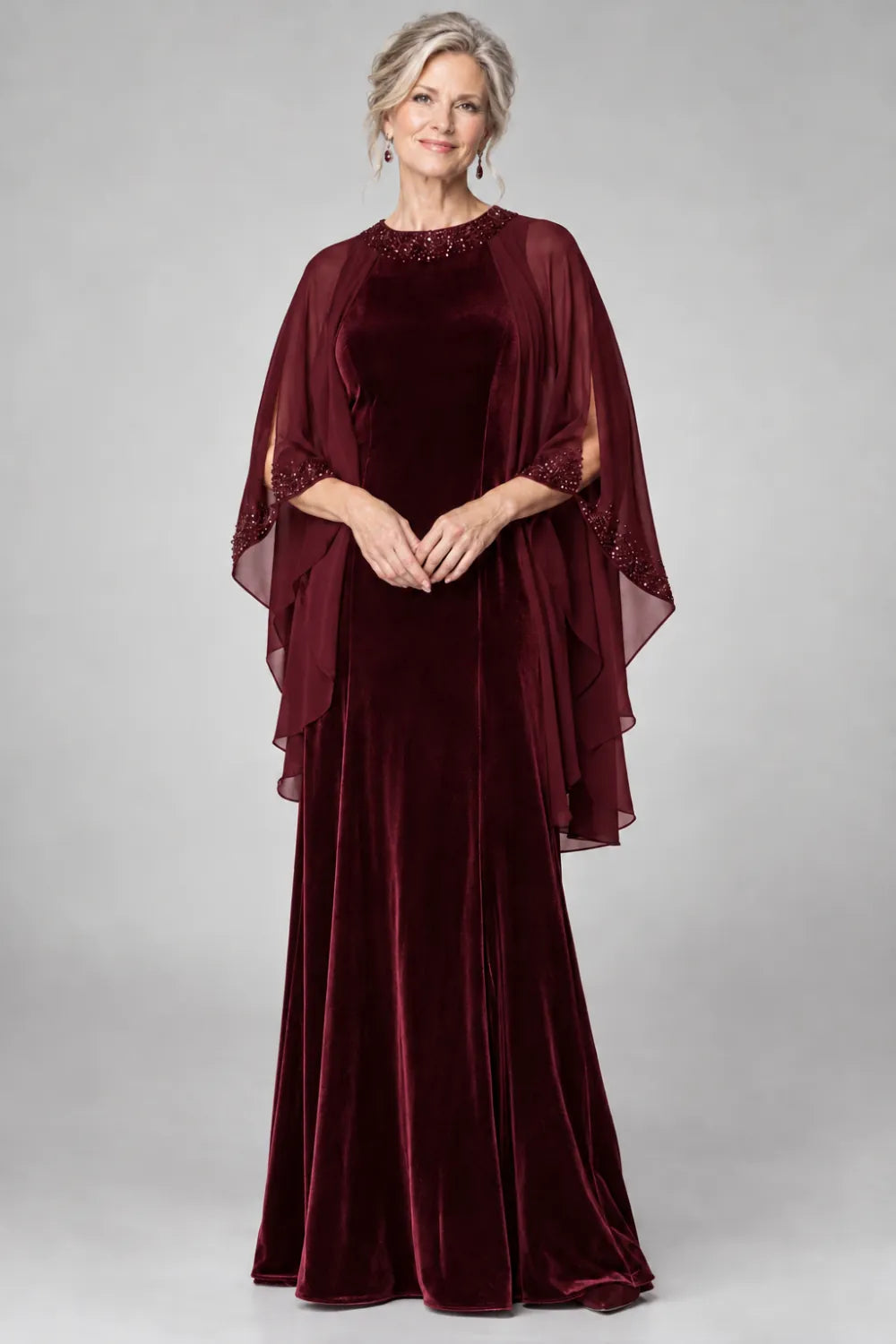 Burgundy dress with beaded round neckline and cascading sheer cape, front view.