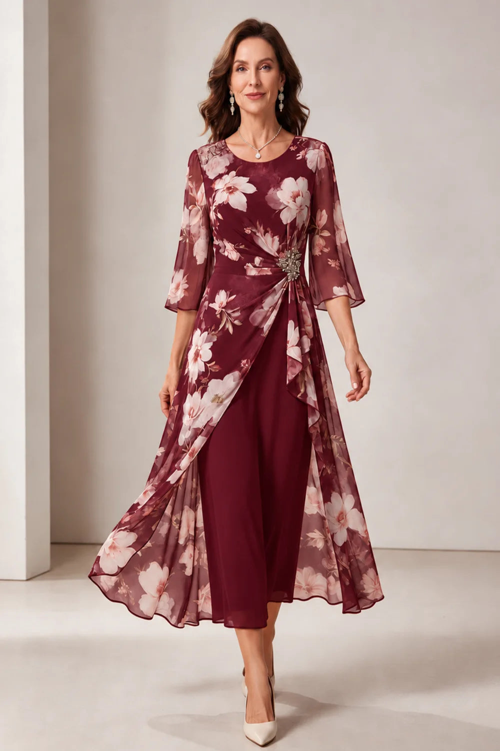 Front view of a burgundy dress with a floral overlay and flared sleeves.