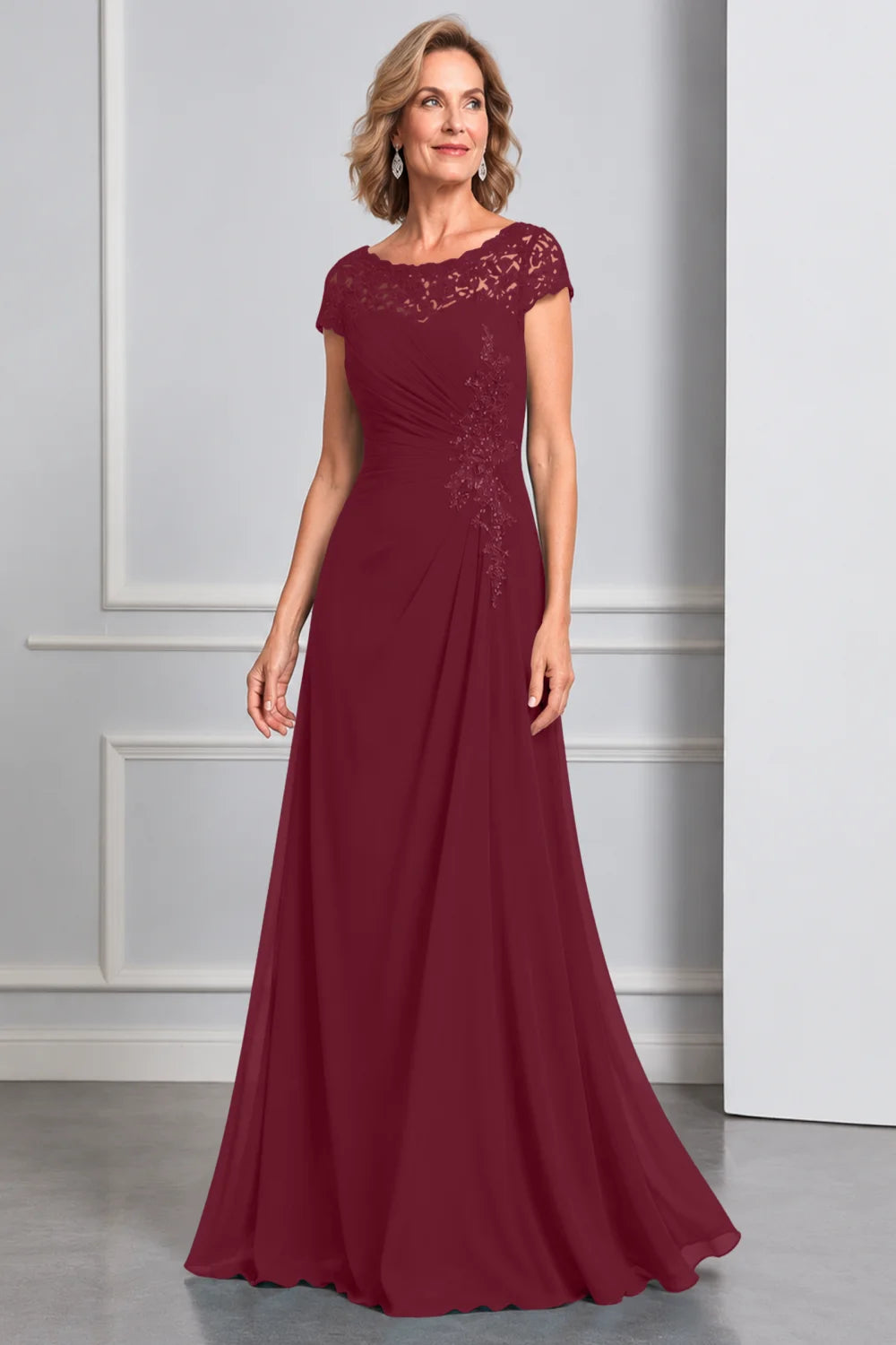 Front view of a burgundy dress with lace cap sleeves and side waist decoration.