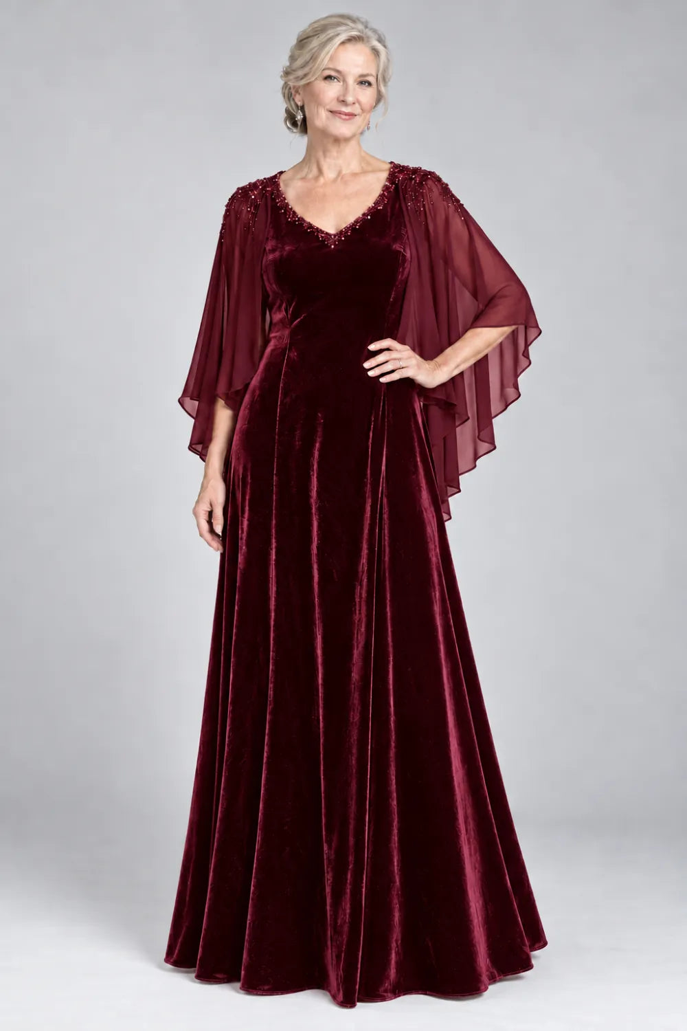 Burgundy dress with beaded v-neck and layered cascading cape, front view.