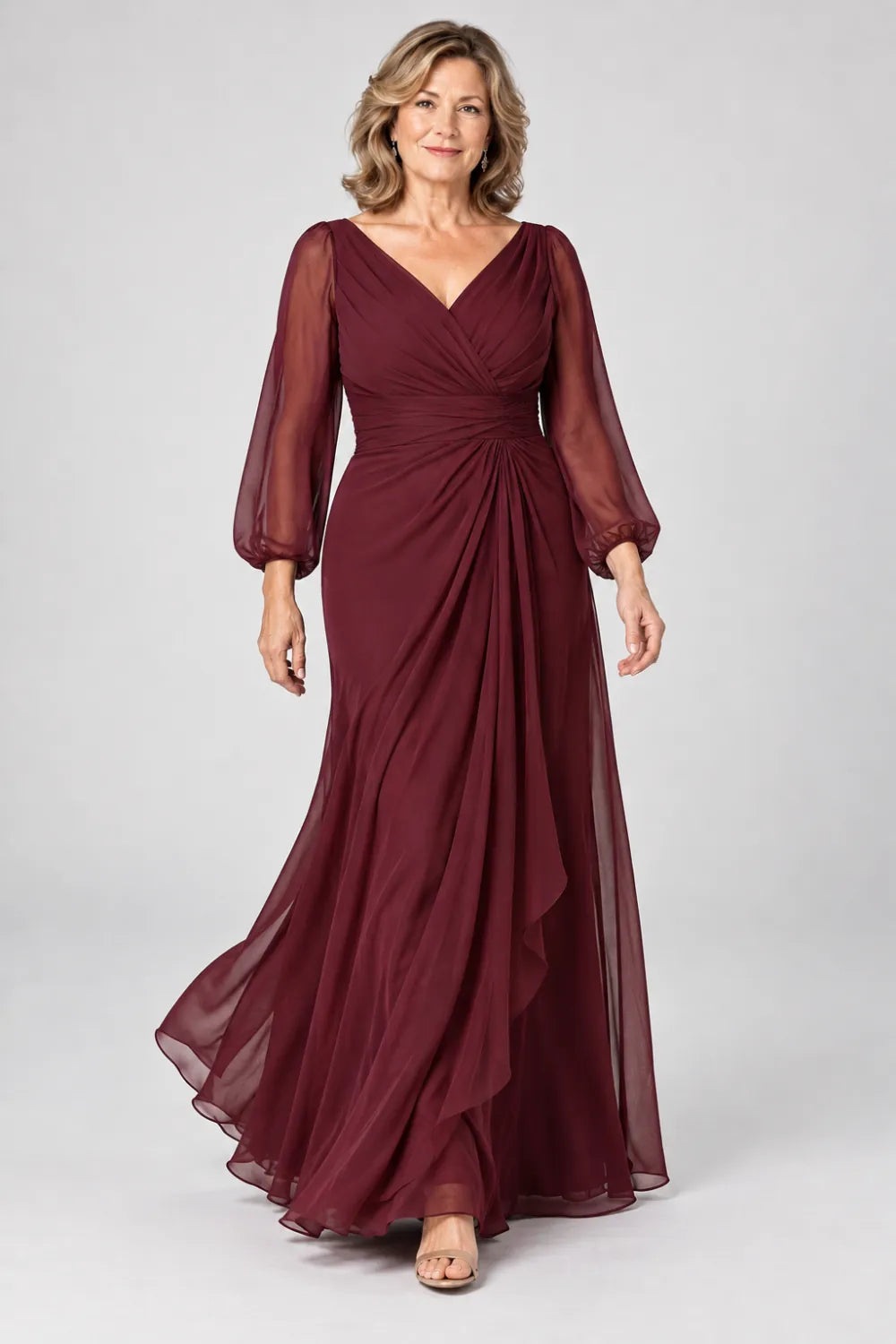 Burgundy dress with crossover bodice, gathered waist and cascading side panel, posed front view.