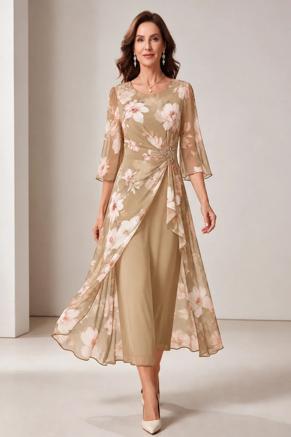 Front view of a champagne dress with a floral overlay and flared sleeves.
