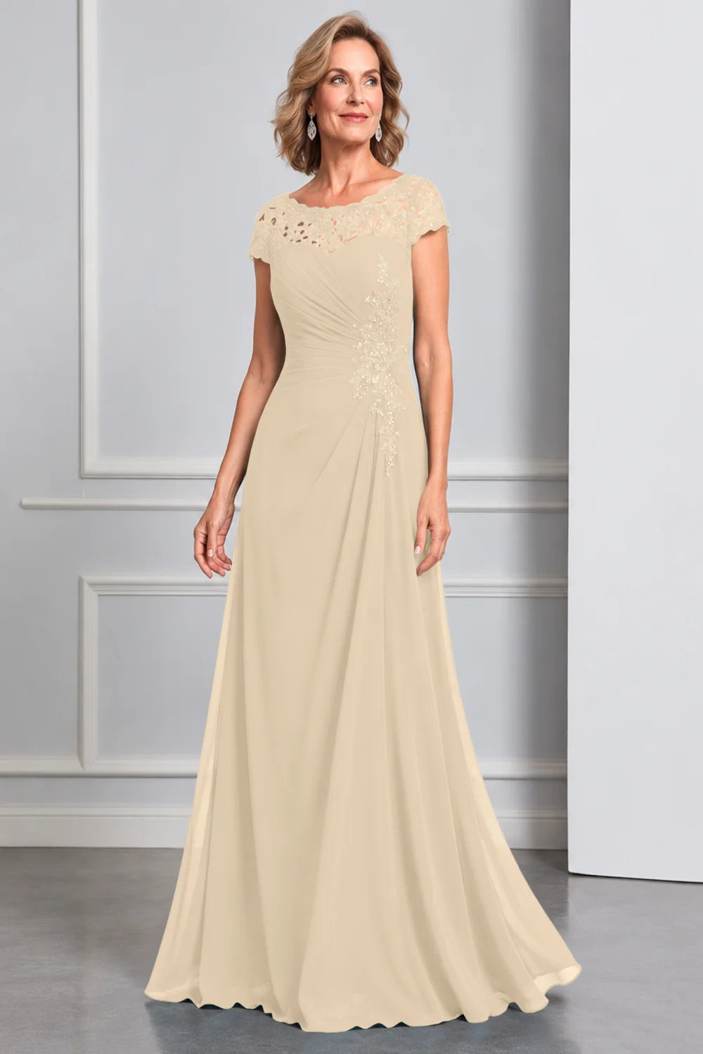 Front view of a champagne dress with lace cap sleeves and side waist decoration.