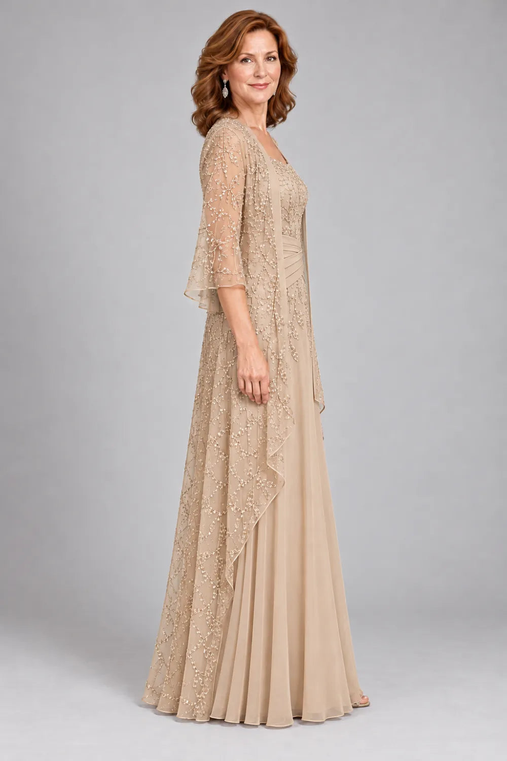 Champagne dress with lace bodice, diagonal waist gathers and cascading skirt panel, side view.