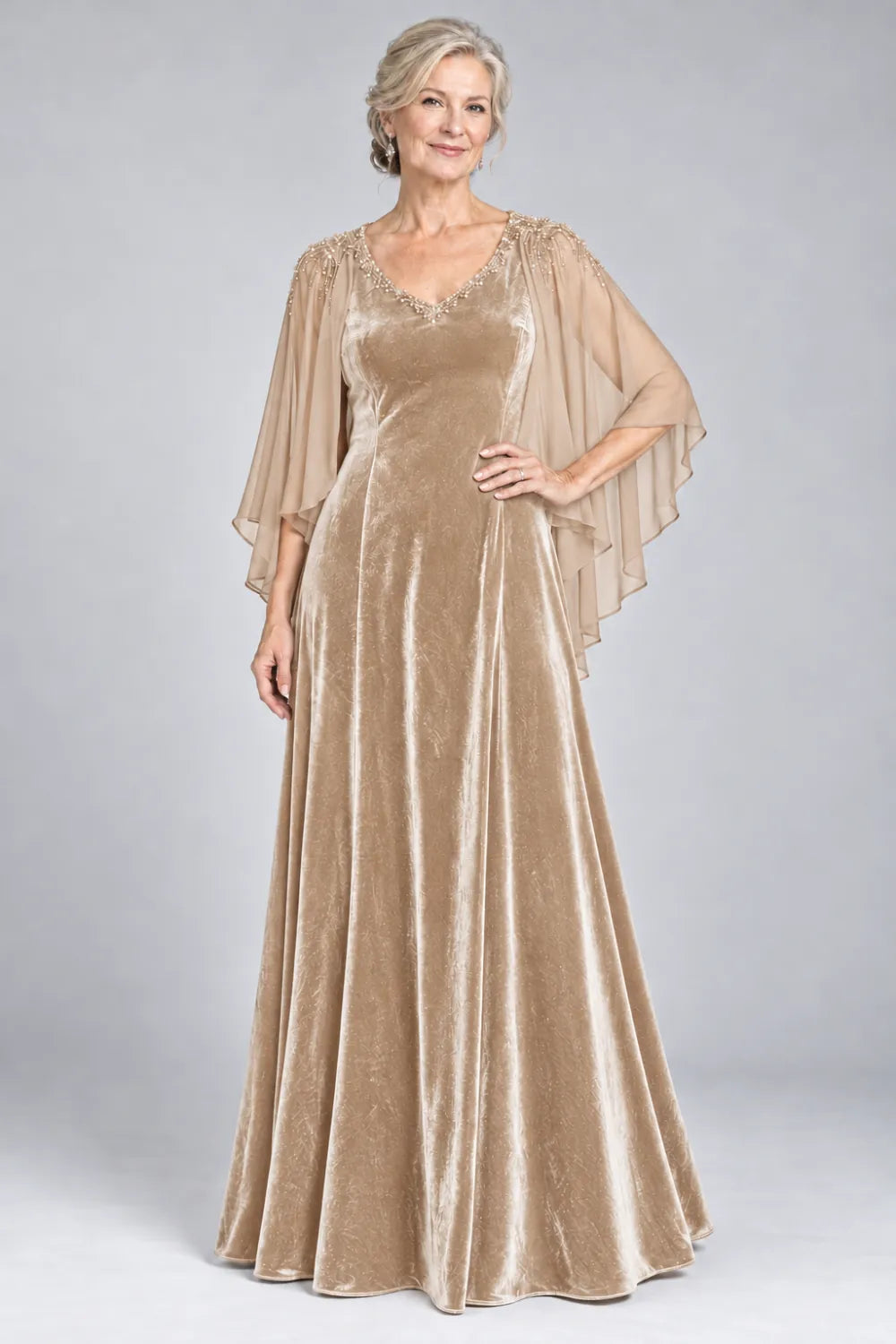 Champagne dress with beaded v-neck and layered cascading cape, front view.