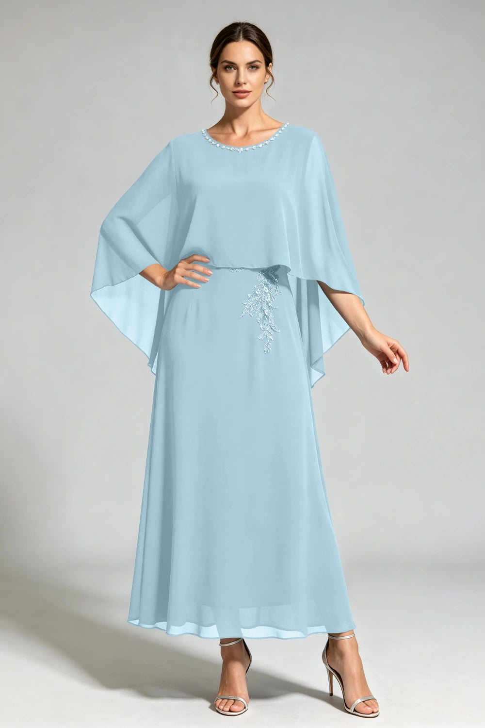 Front view of the dusty blue cape dress with a beaded round neckline and tonal floral applique.