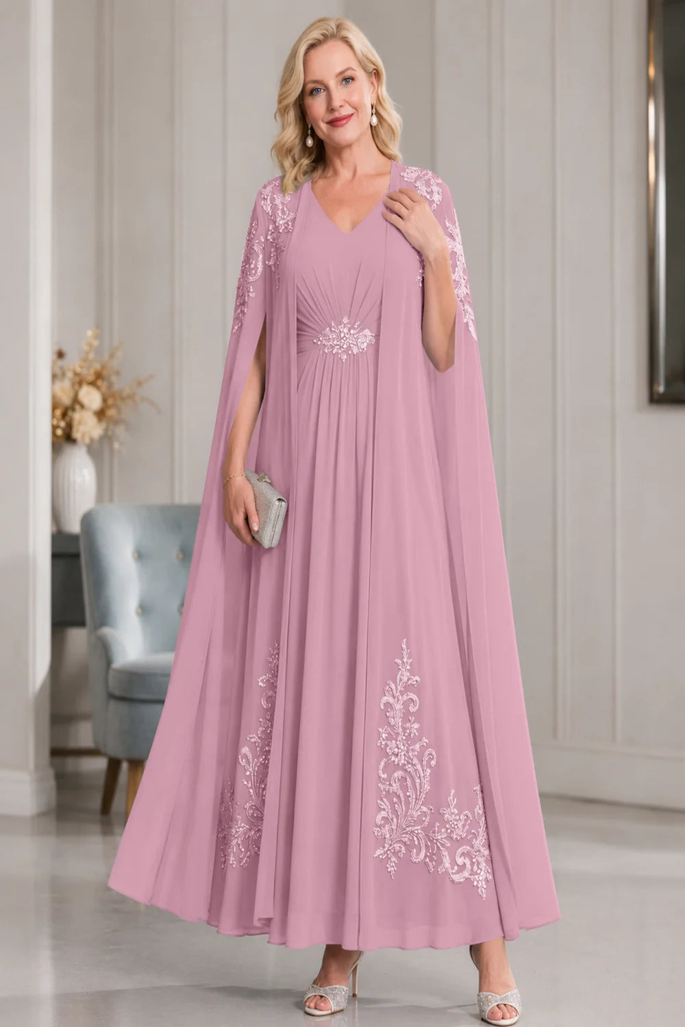 Front view of a dusty pink dress with open cape panels and pale skirt motifs.