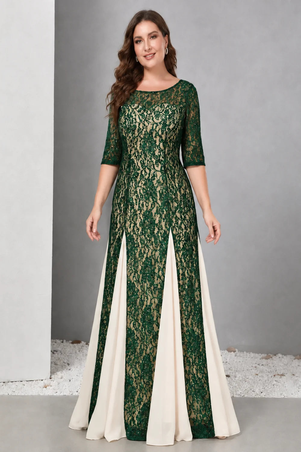 Front view of a emerald green dress with lace and contrasting pale skirt panels.