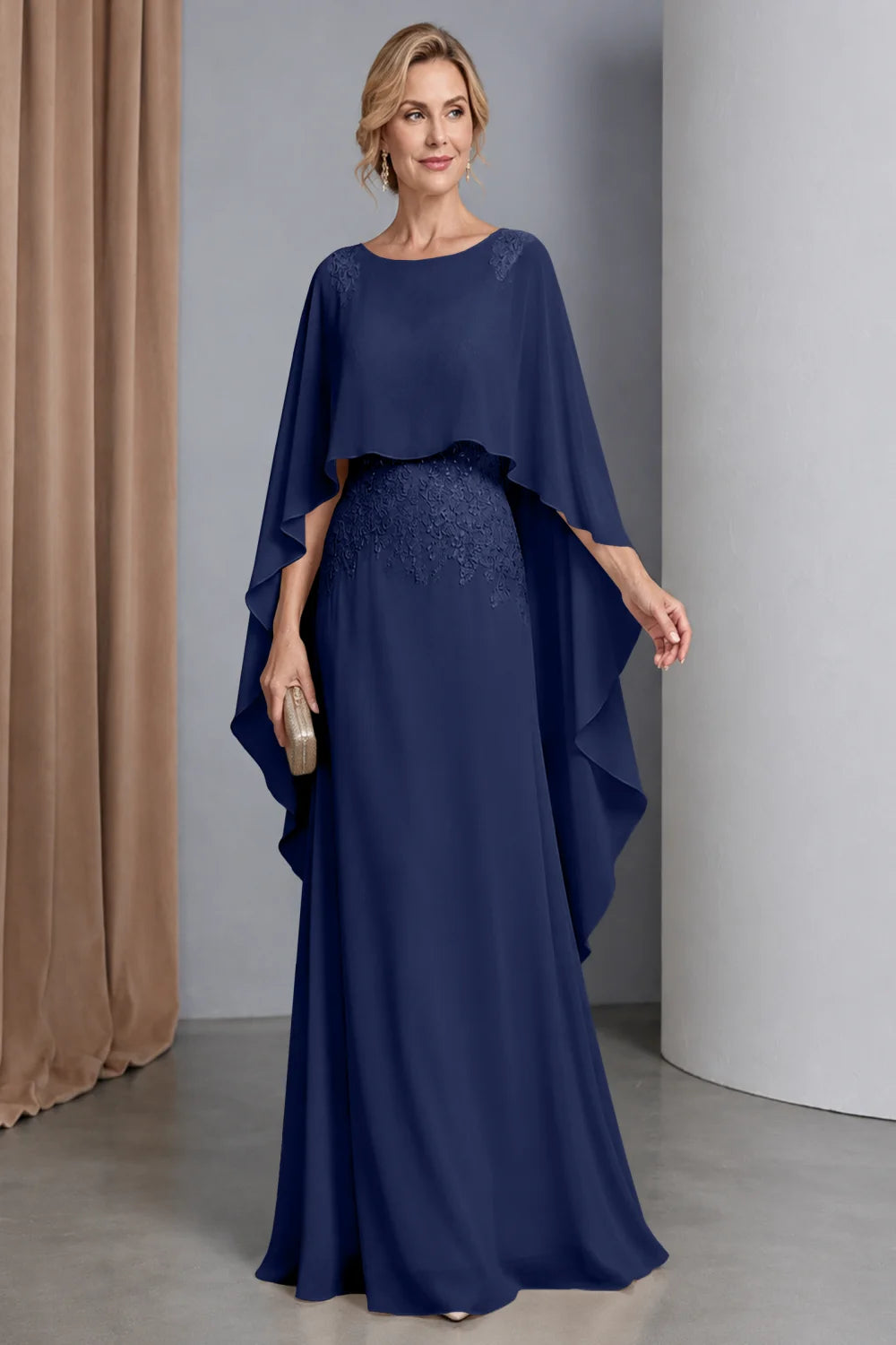 Front view of a navy blue dress with a curved cape front and embellished waist.