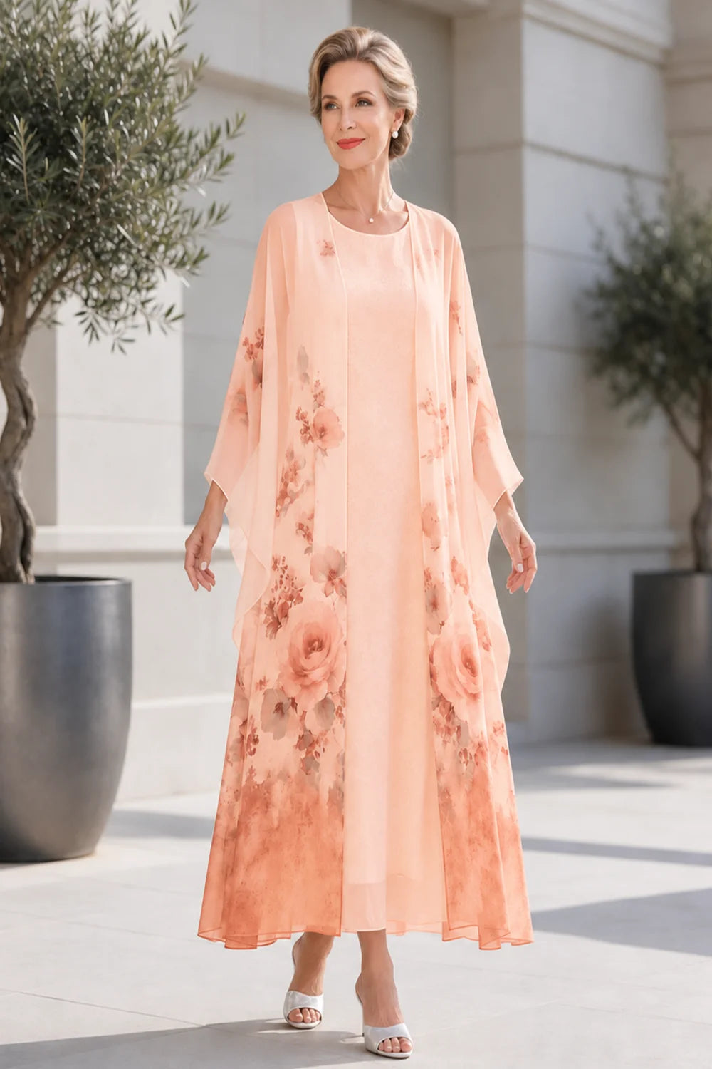 Front view of a peach dress with a long floral outer layer.