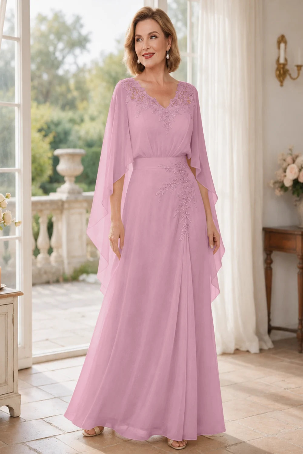 Front view of a pink dress with a lace V neckline and open cape panels.