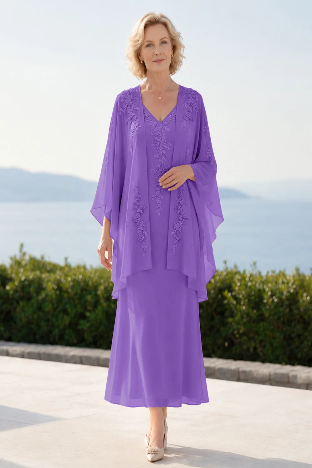 Front view of a purple dress with a decorated neckline and long upper overlay.