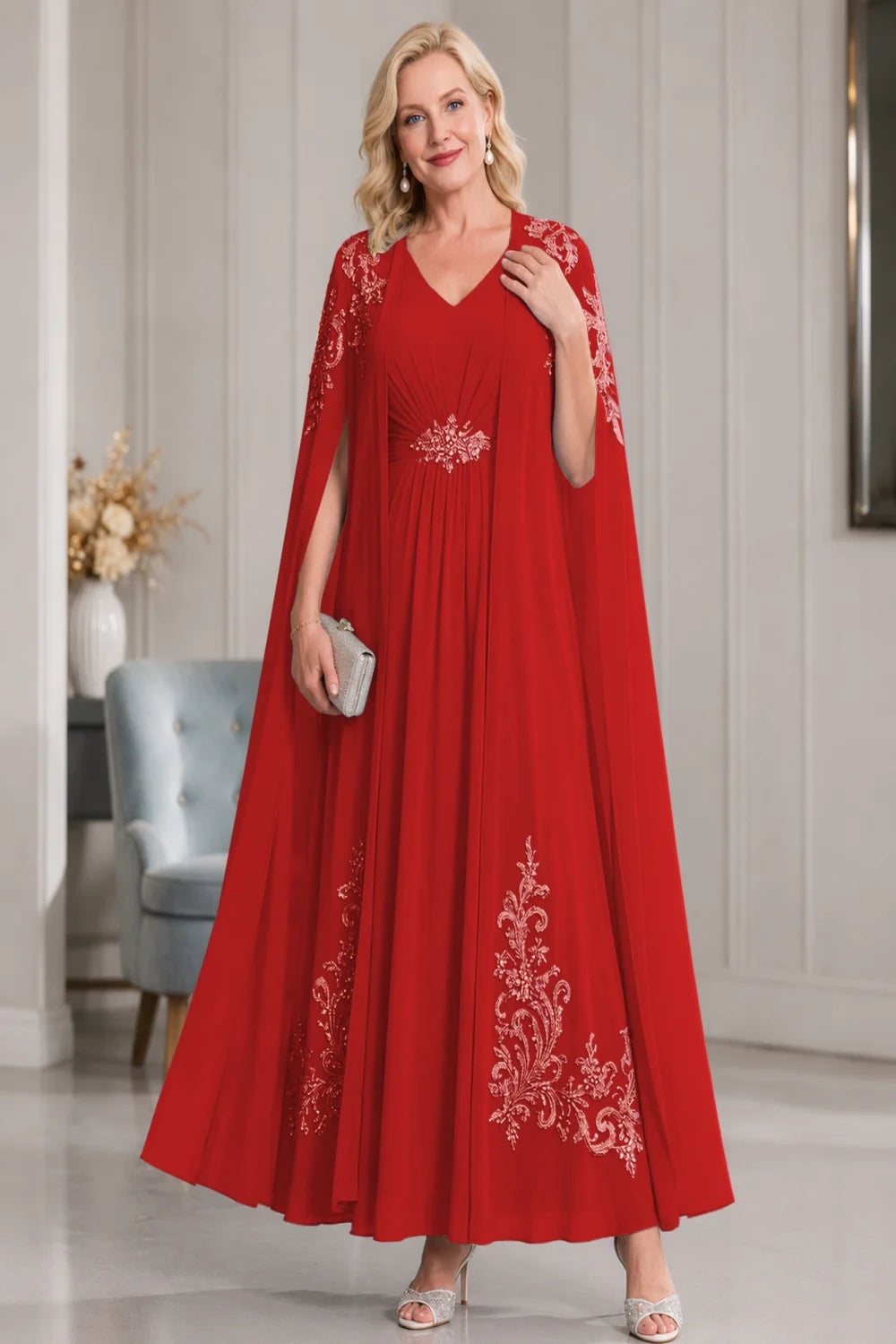 Front view of a red dress with open cape panels and pale skirt motifs.