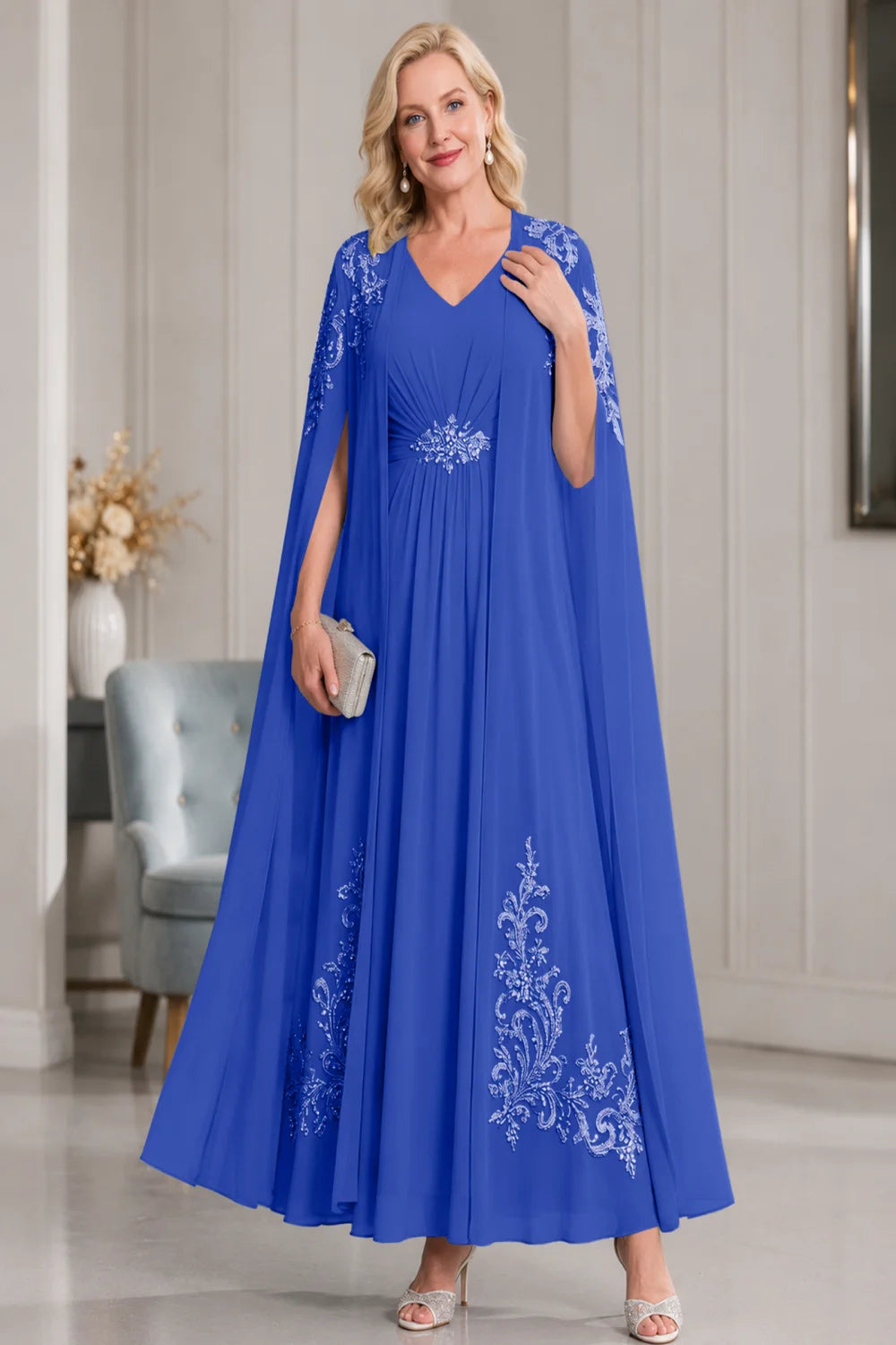 Front view of a royal blue dress with open cape panels and pale skirt motifs.