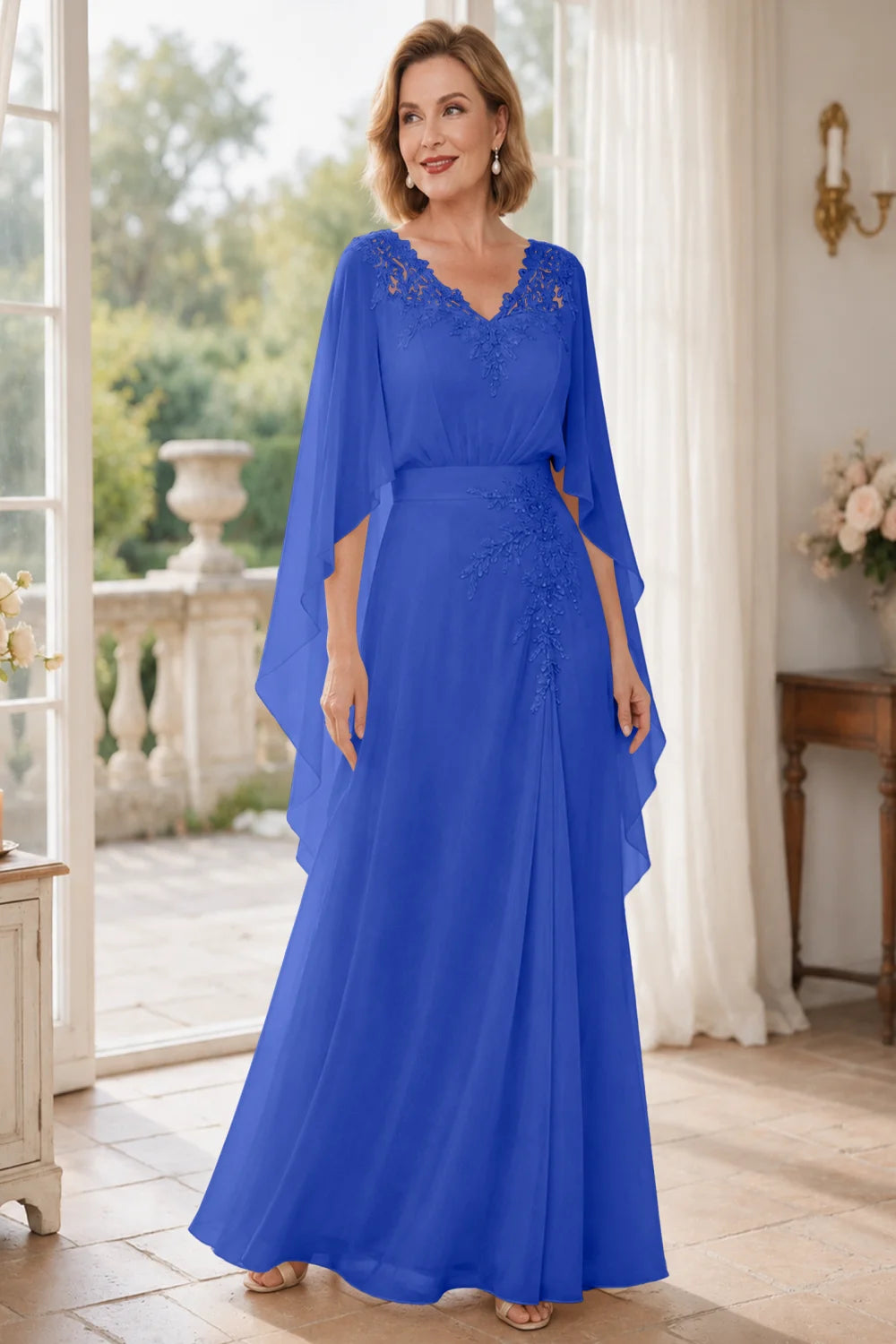 Front view of a royal blue dress with a lace V neckline and open cape panels.
