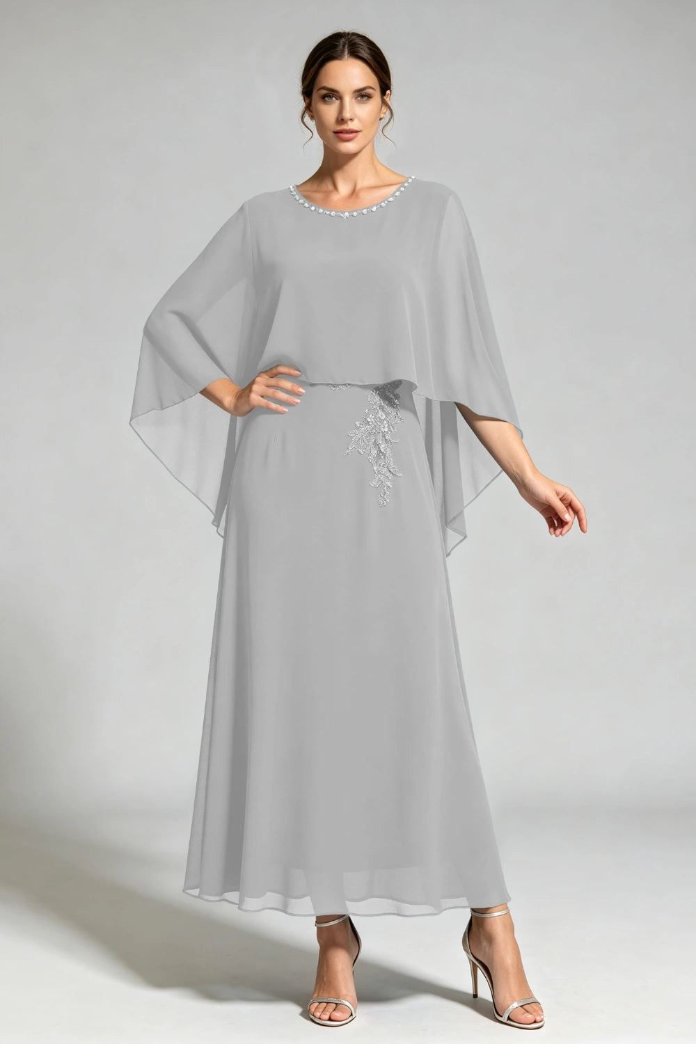 Front view of the silver gray cape dress with a beaded round neckline and tonal floral applique.