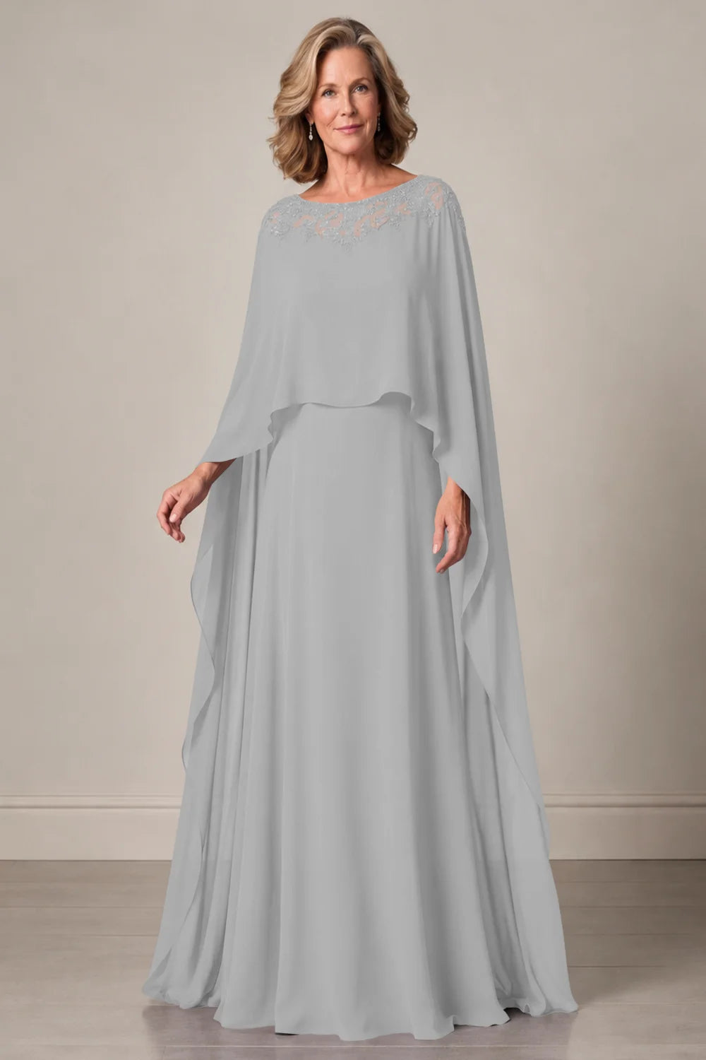 Front view of a silver gray dress with a decorated neckline and long cape panels.