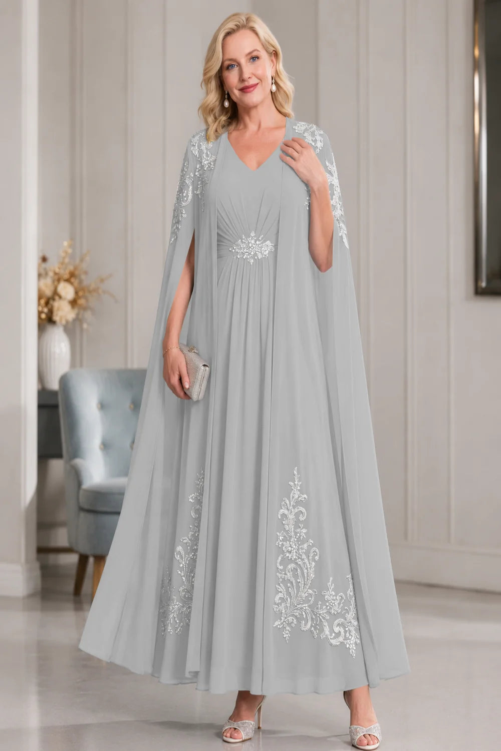 Front view of a silver gray dress with open cape panels and pale skirt motifs.