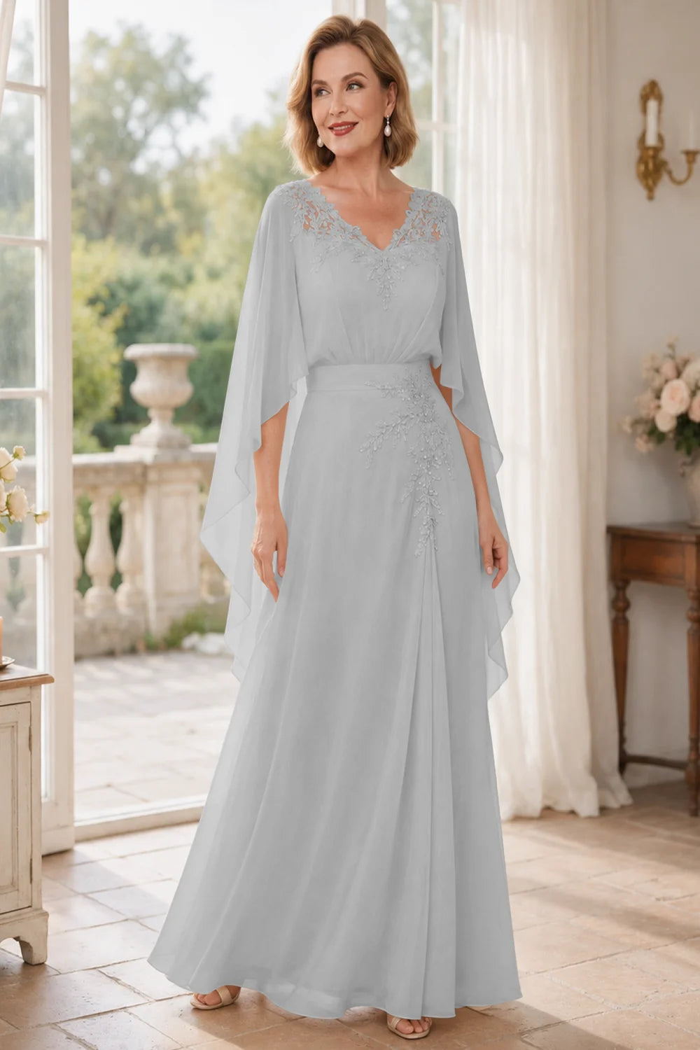 Front view of a silver gray dress with a lace V neckline and open cape panels.