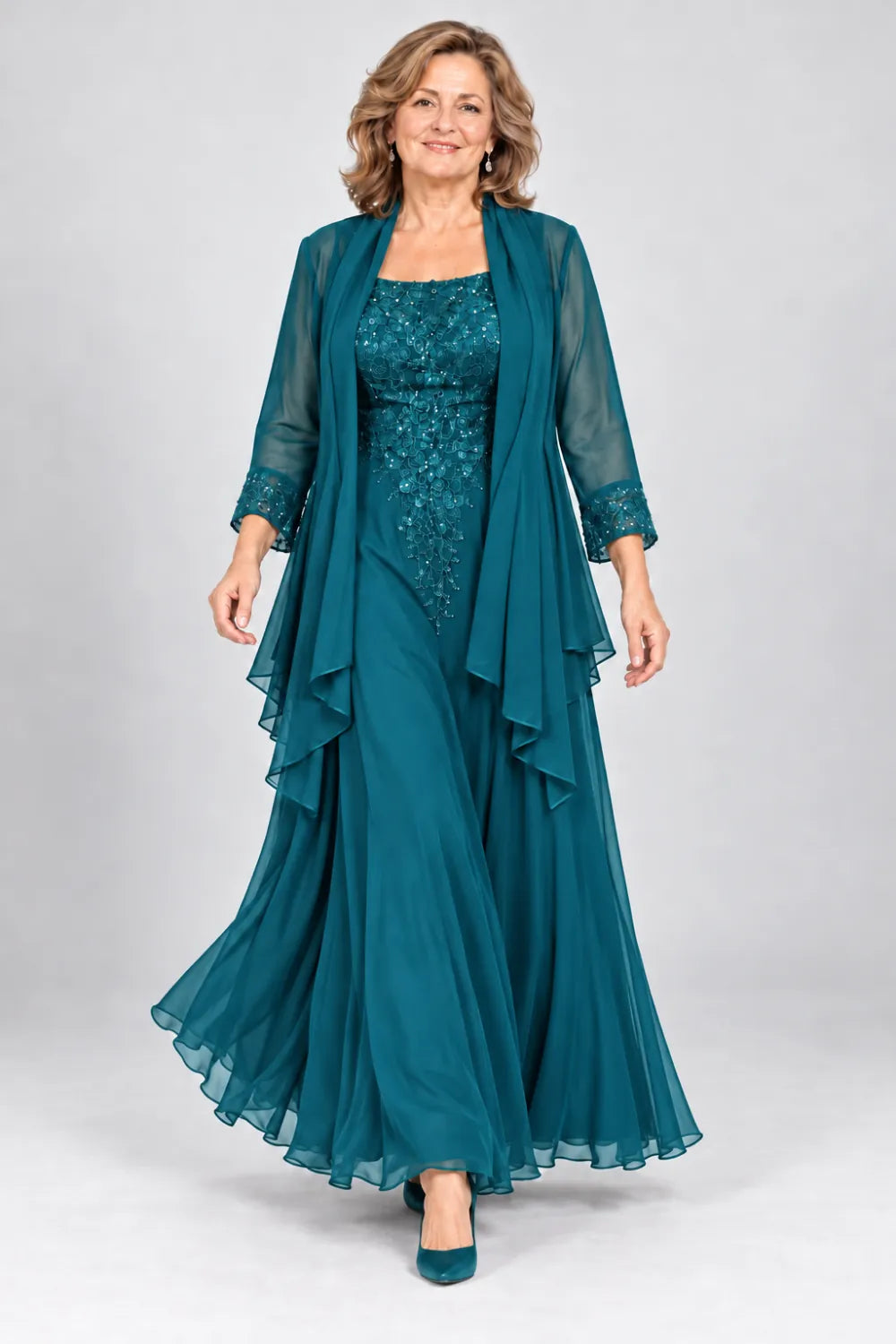 Teal dress with floral bodice and matching decorated cuffs, front view.