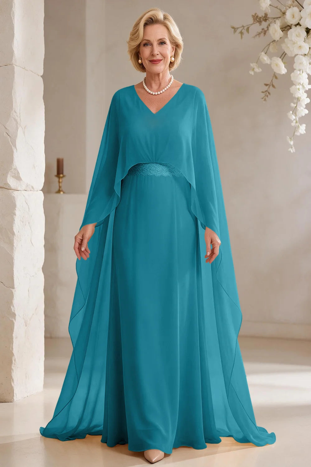 Front view of a teal dress with long cape panels and a flared skirt.