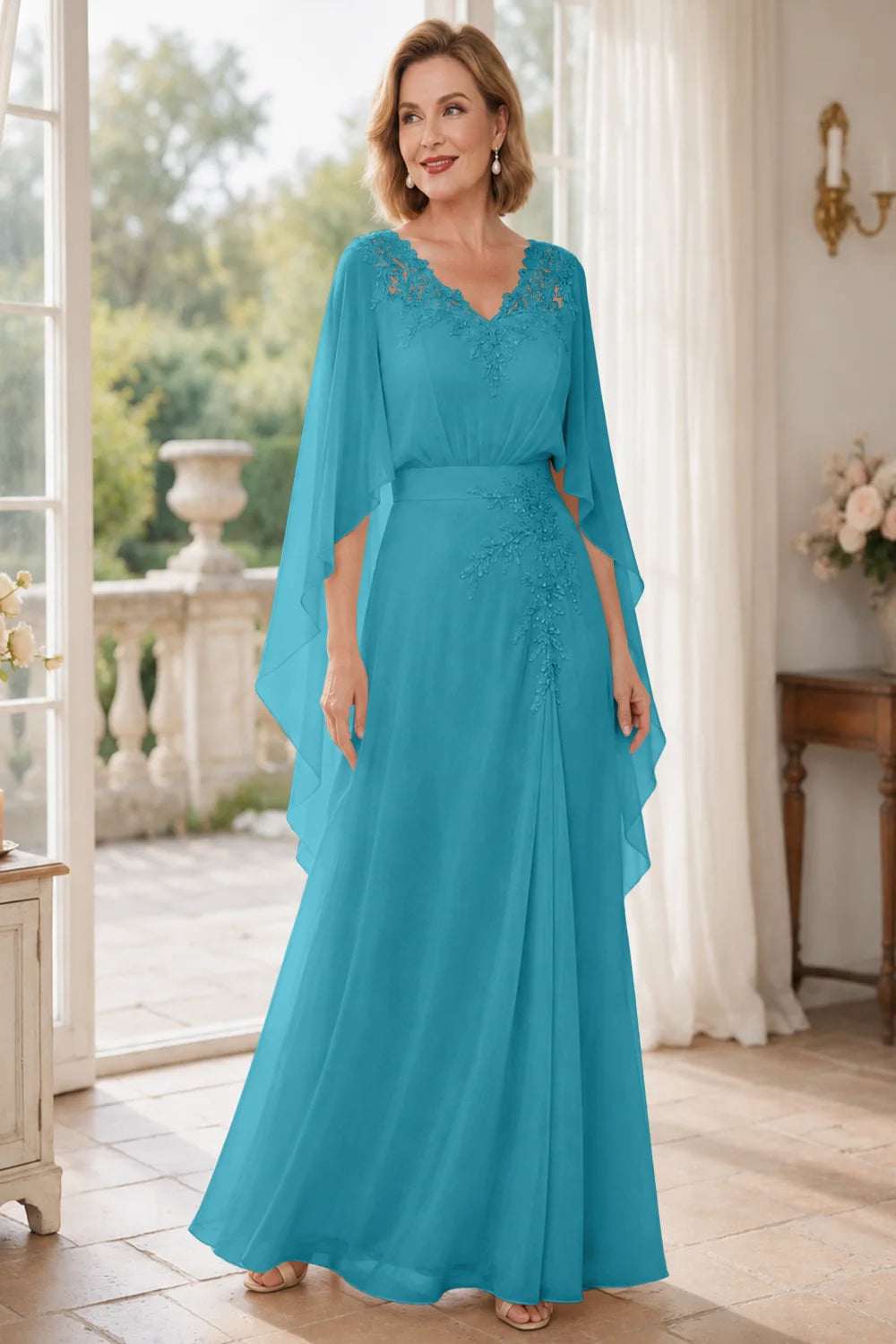 Front view of a teal dress with a lace V neckline and open cape panels.