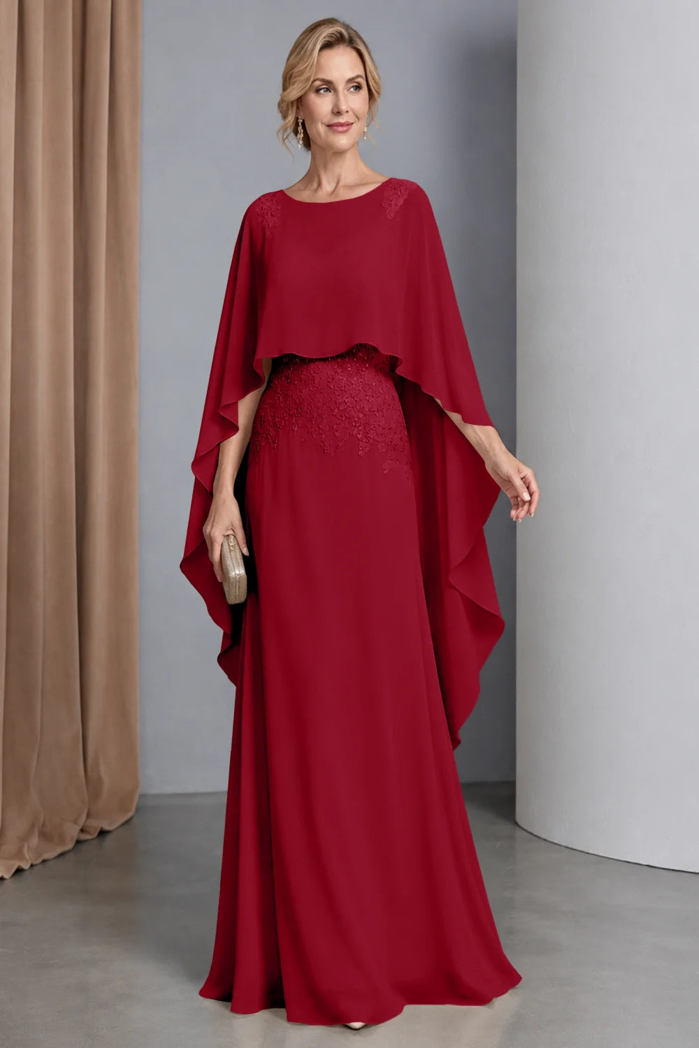 Front view of a wine red dress with a curved cape front and embellished waist.