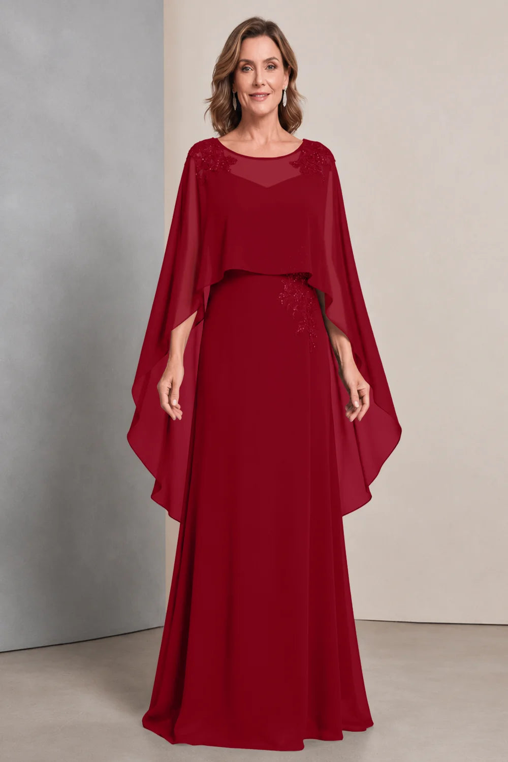 Front view of a wine red dress with a sheer neckline and long cape sides.