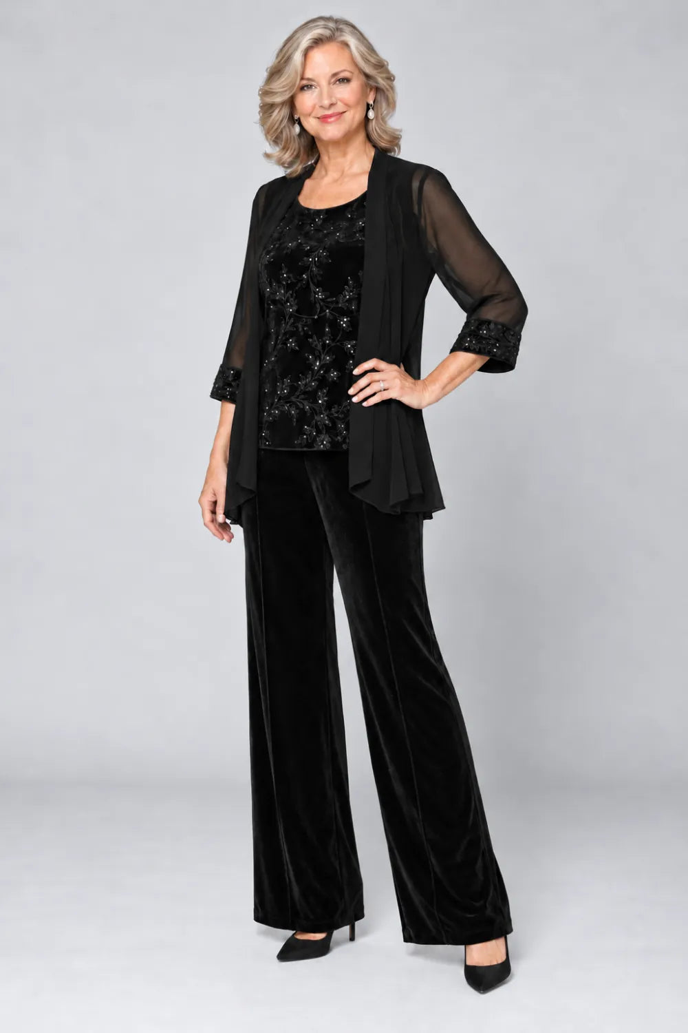 Black pant suit with tonal floral top and matching cuff panels, front view.