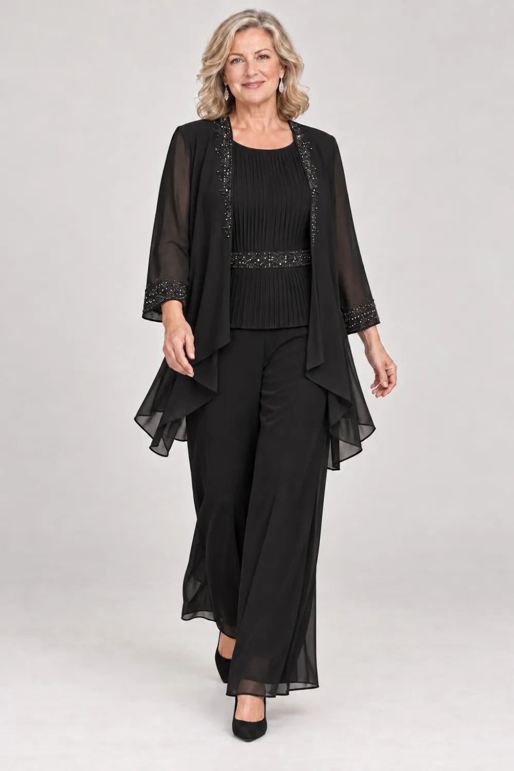 Black pant suit with pleated top and beaded waist, jacket edges and cuffs, front view.