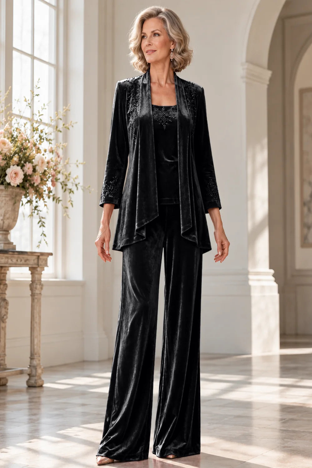 Front view of a black pant suit with a waterfall jacket and matching trousers.