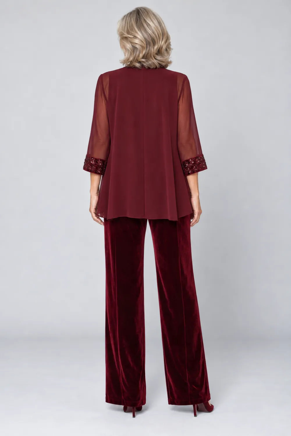 Back view of a burgundy wide-leg pant suit with open sheer three-quarter jacket.