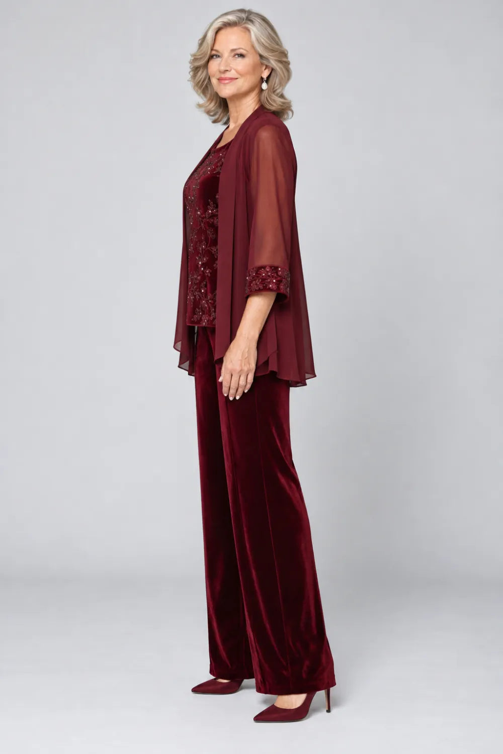 Burgundy pant suit with tonal floral top and matching cuff panels, side view.