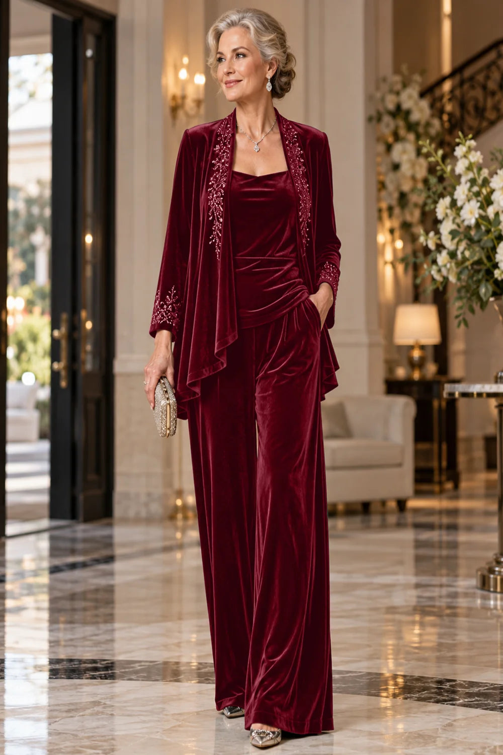 Front view of a burgundy pant suit with an embellished jacket and matching trousers.