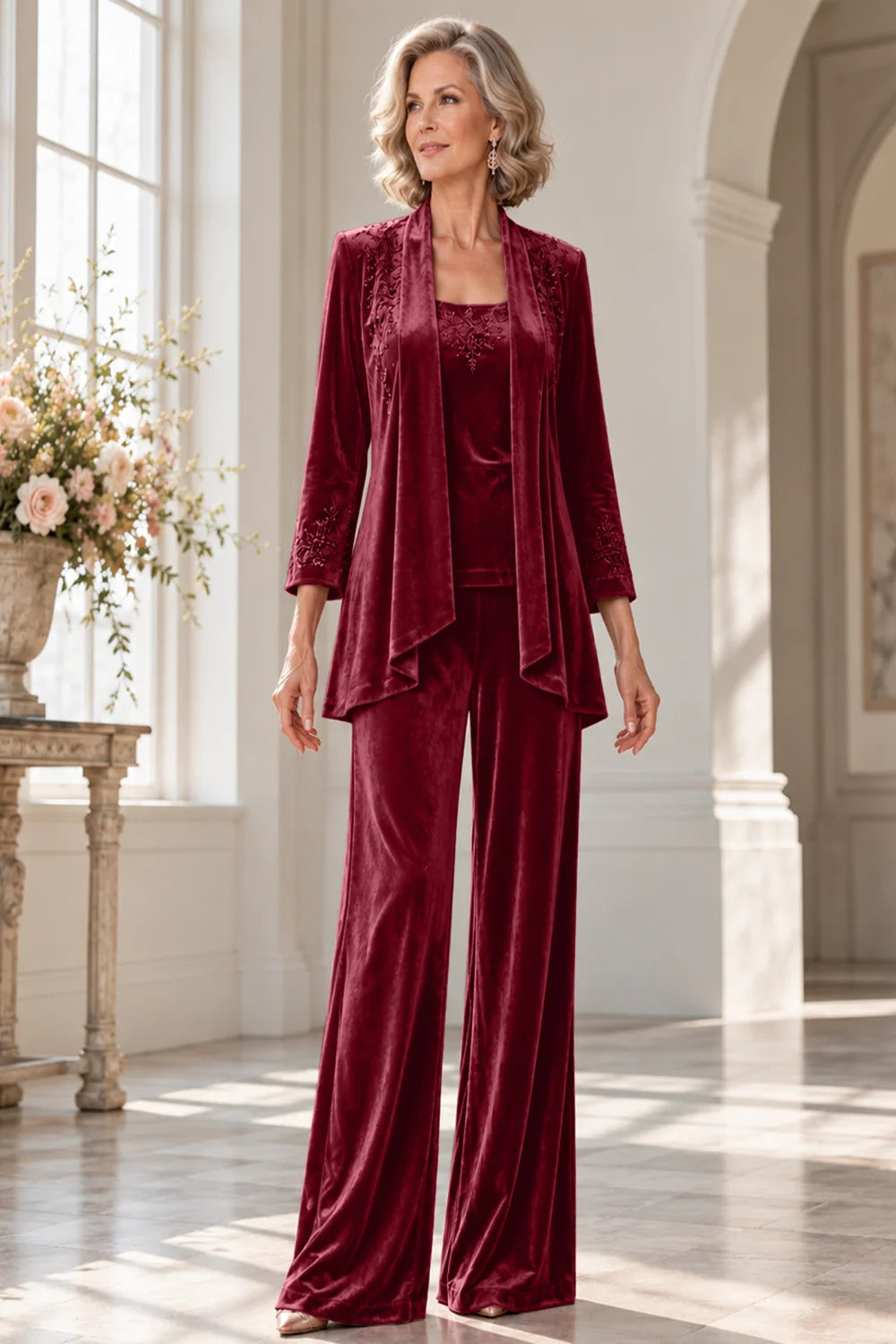 Front view of a burgundy pant suit with a waterfall jacket and matching trousers.