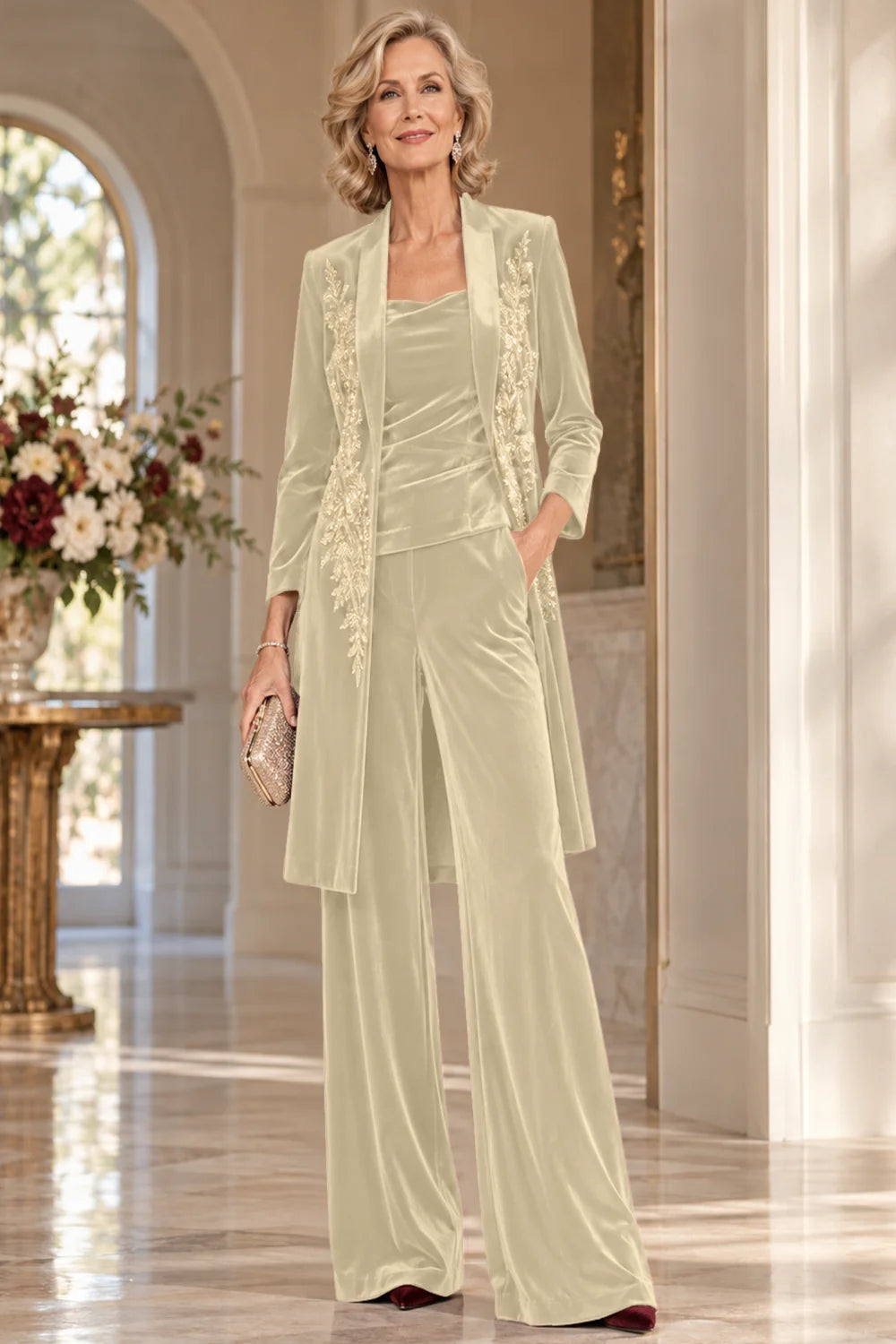Front view of a champagne pant suit with a floral-trimmed long jacket and wide-leg trousers.