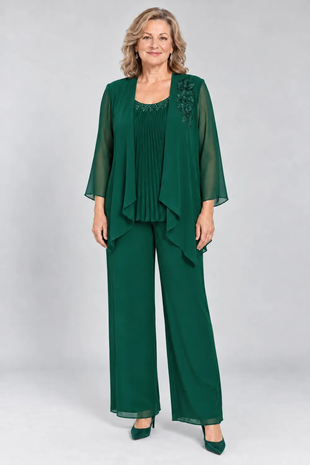 Emerald Green pant suit with fine pleats, decorated neckline and floral shoulder motif, front view.