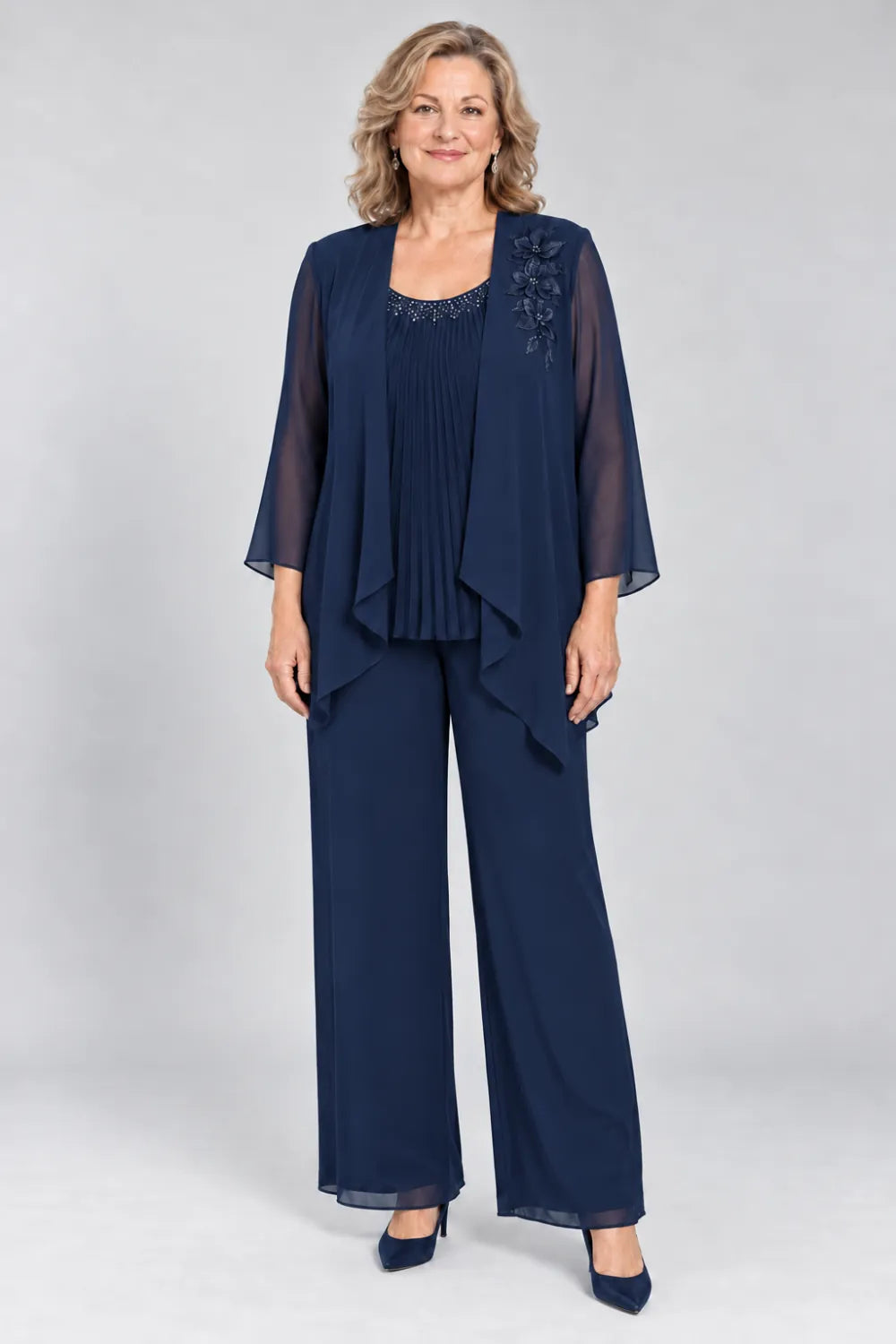 Navy Blue pant suit with fine pleats, decorated neckline and floral shoulder motif, front view.