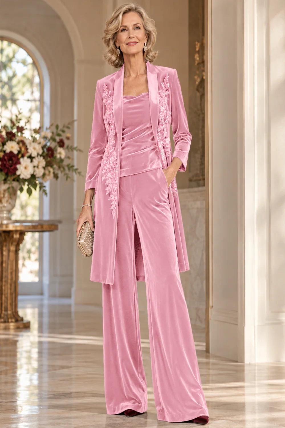 Front view of a pink pant suit with a floral-trimmed long jacket and wide-leg trousers.