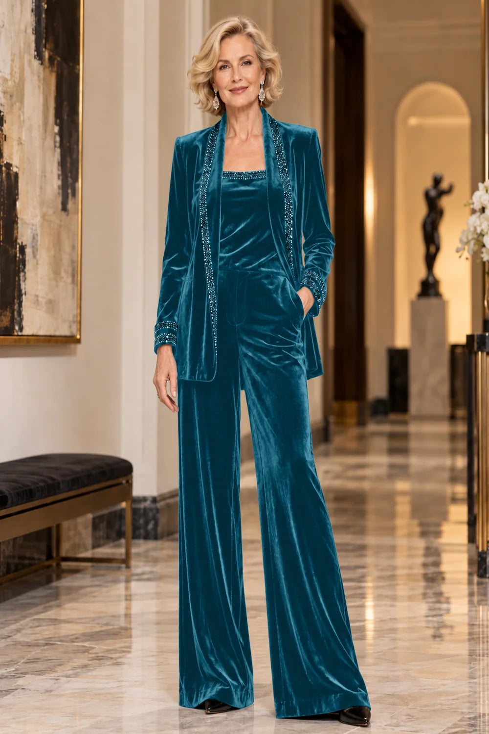 Front view of a teal pant suit with a trimmed jacket, matching top and wide-leg trousers.
