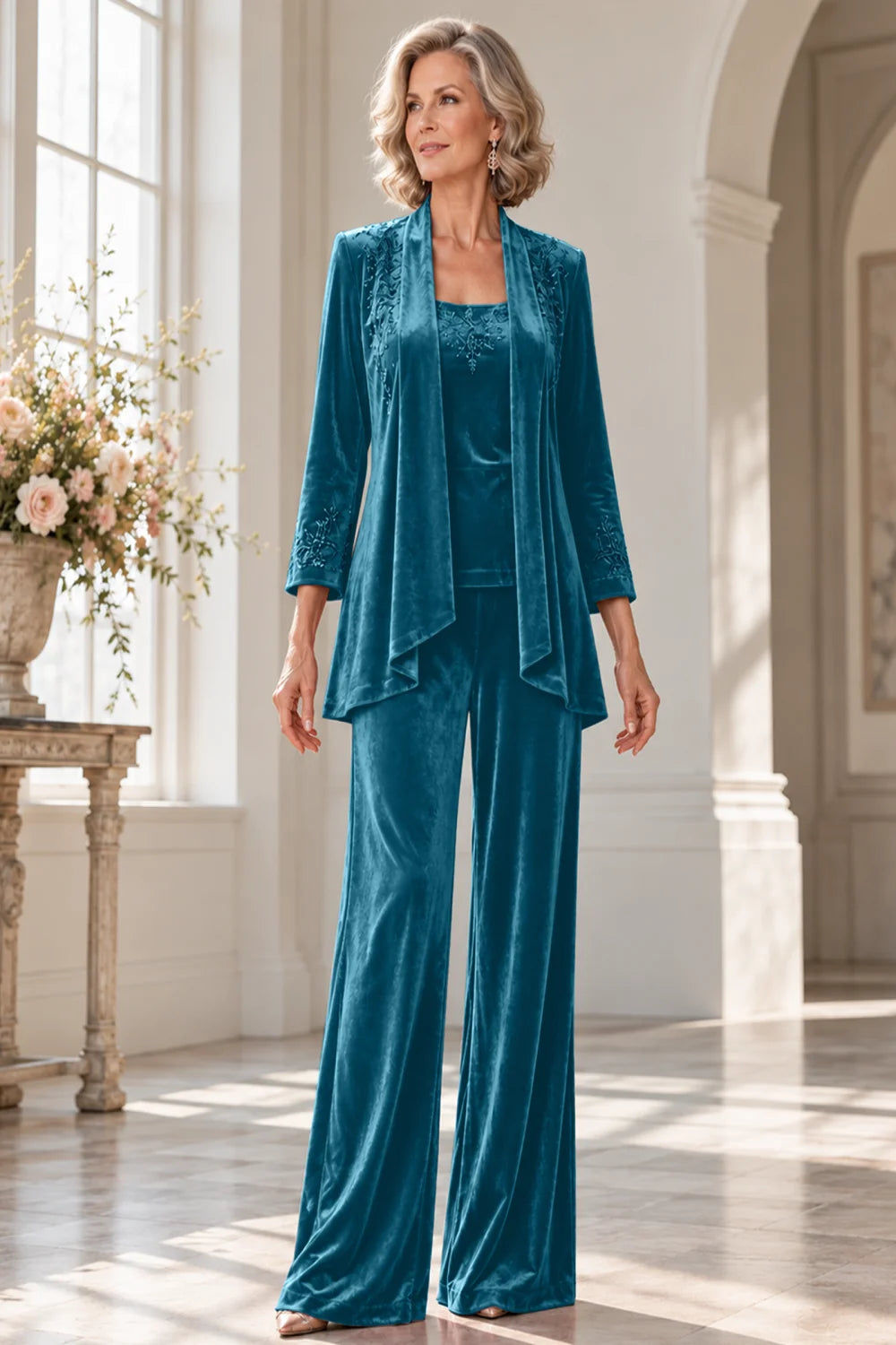 Front view of a teal pant suit with a waterfall jacket and matching trousers.