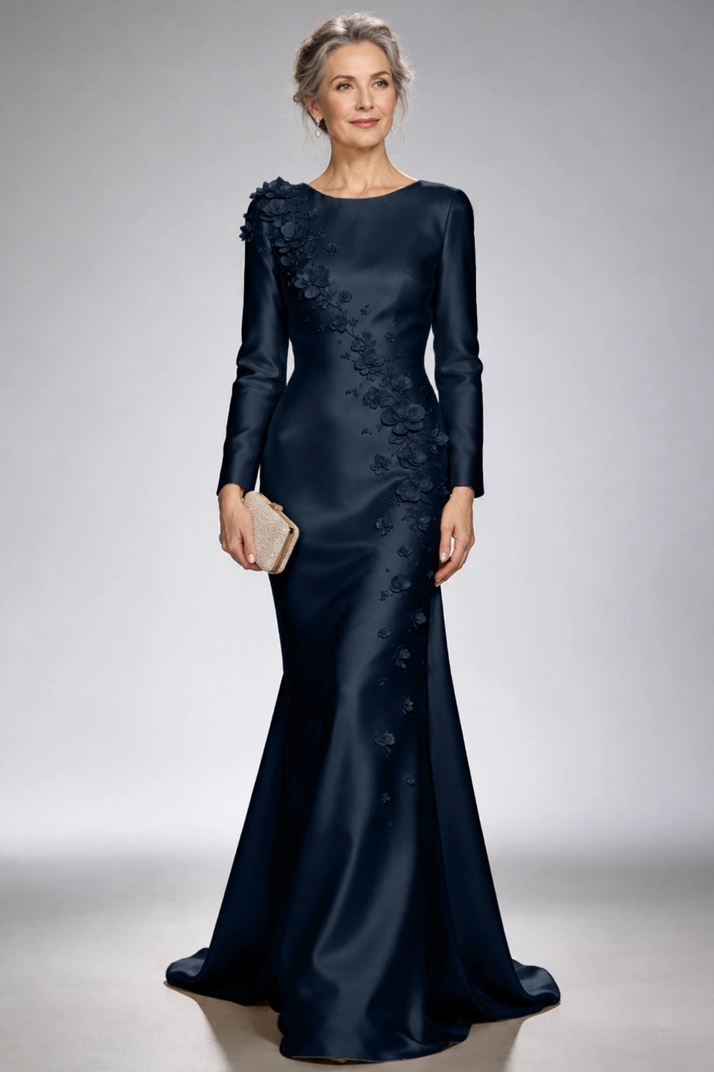 Front view of the navy blue satin mermaid dress with long sleeves and diagonal floral appliques across the bodice and skirt.