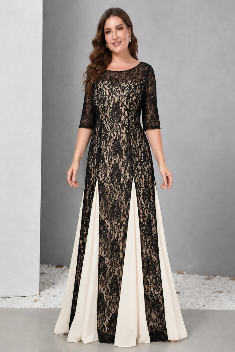 Front view of a black dress with lace and contrasting pale skirt panels.